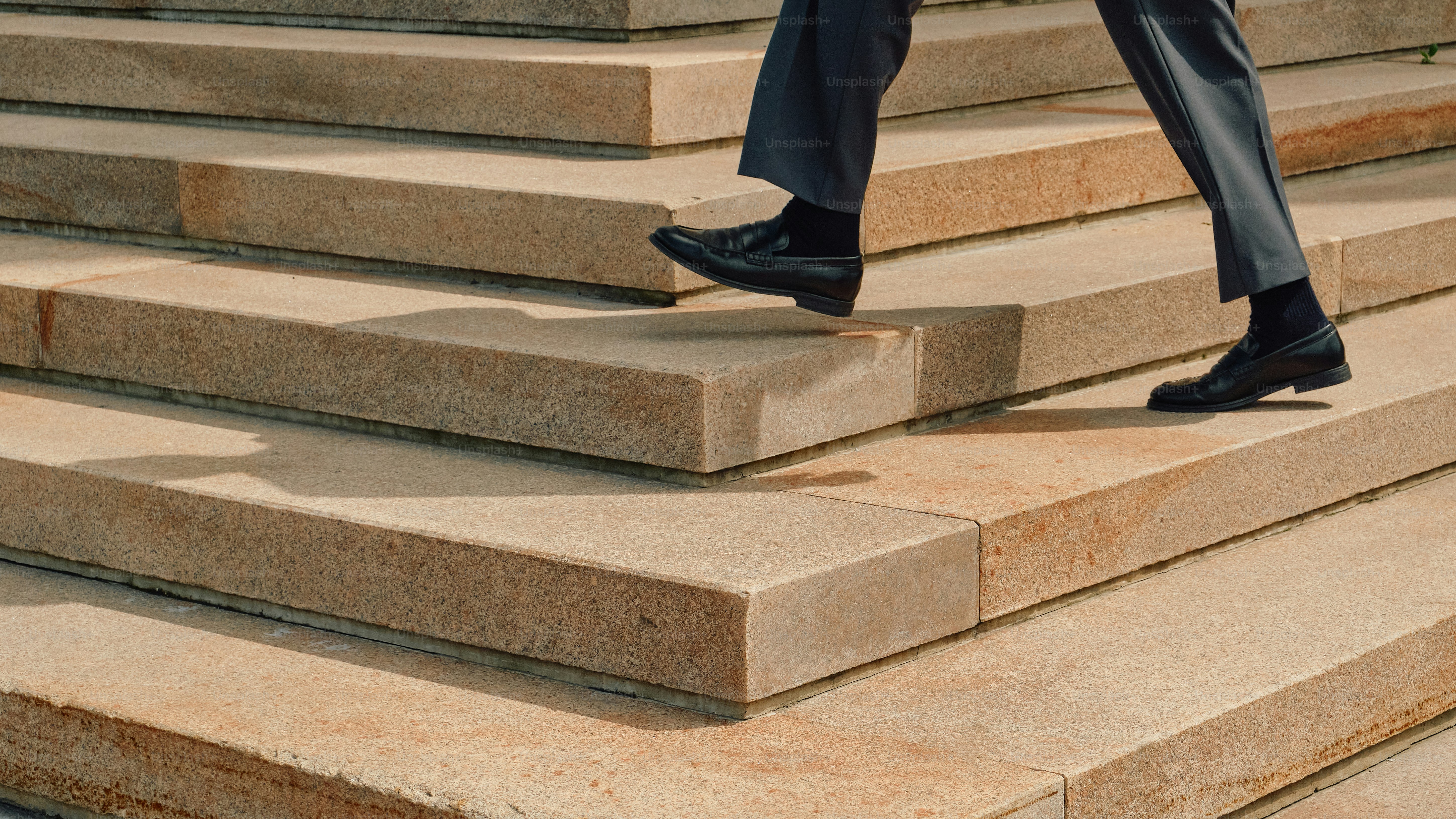 Man in loafers walking down stone stairs