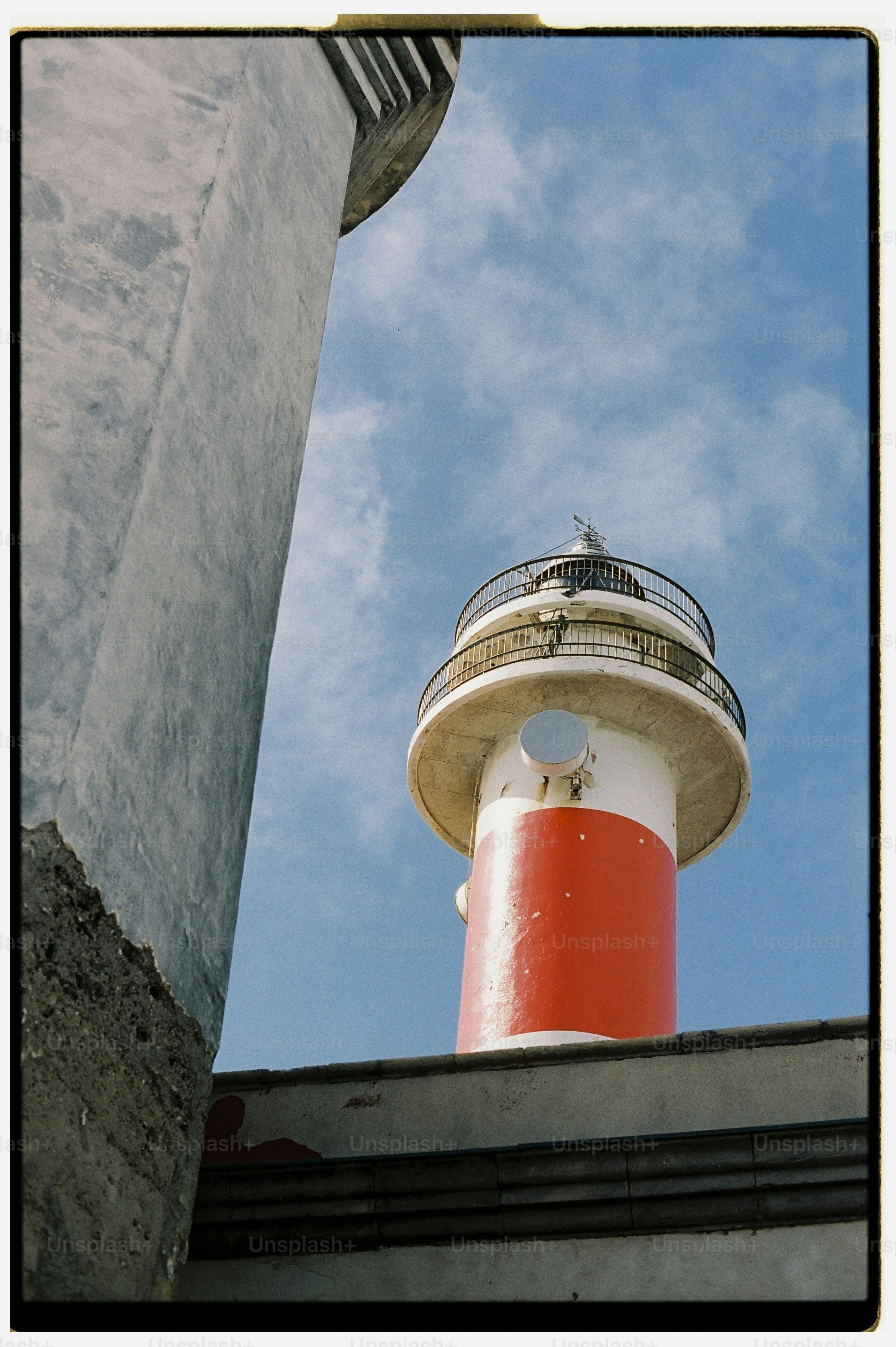 Red and white lighthouse under blue sky