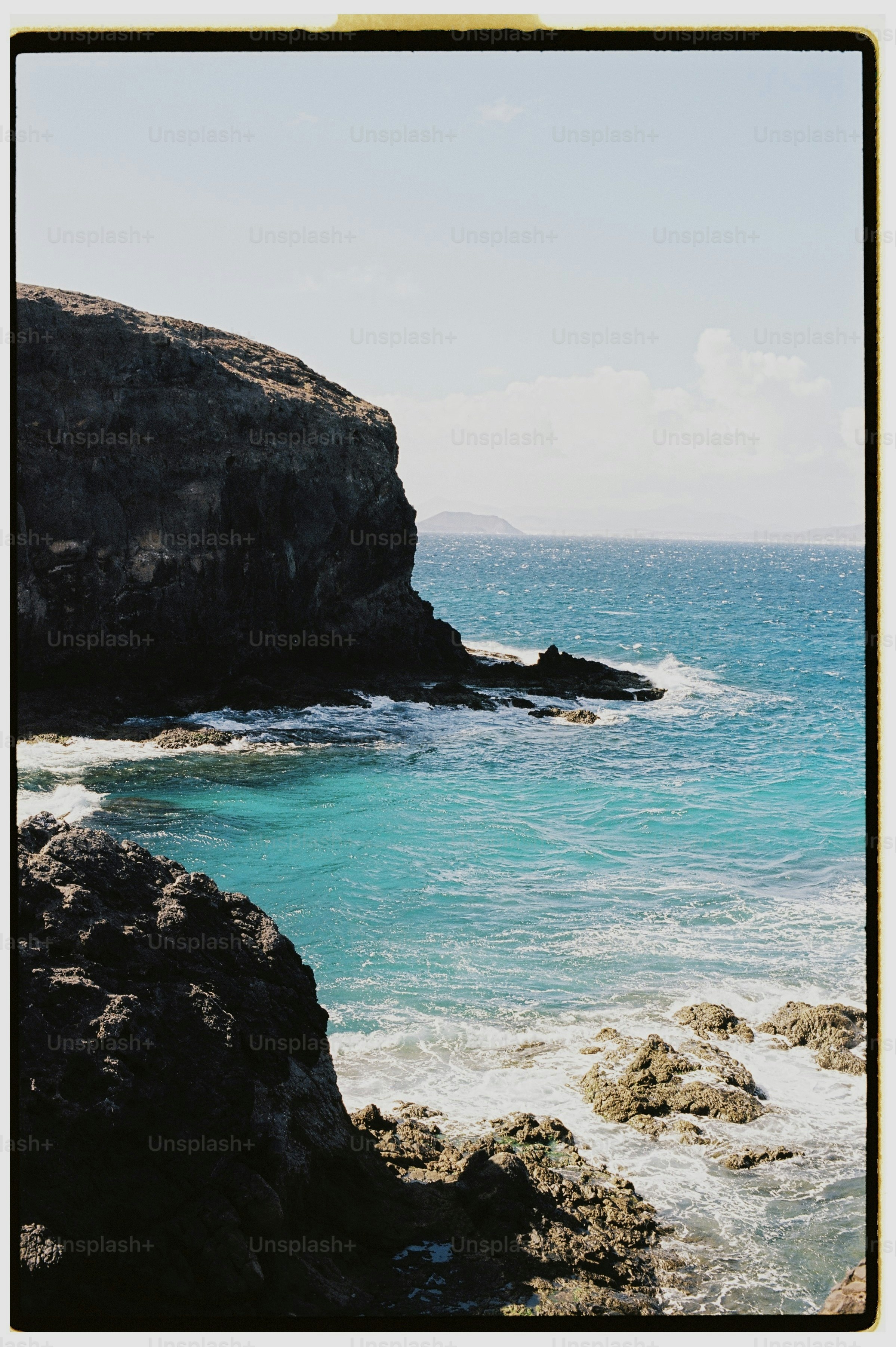Rocky coastline with turquoise ocean water and crashing waves