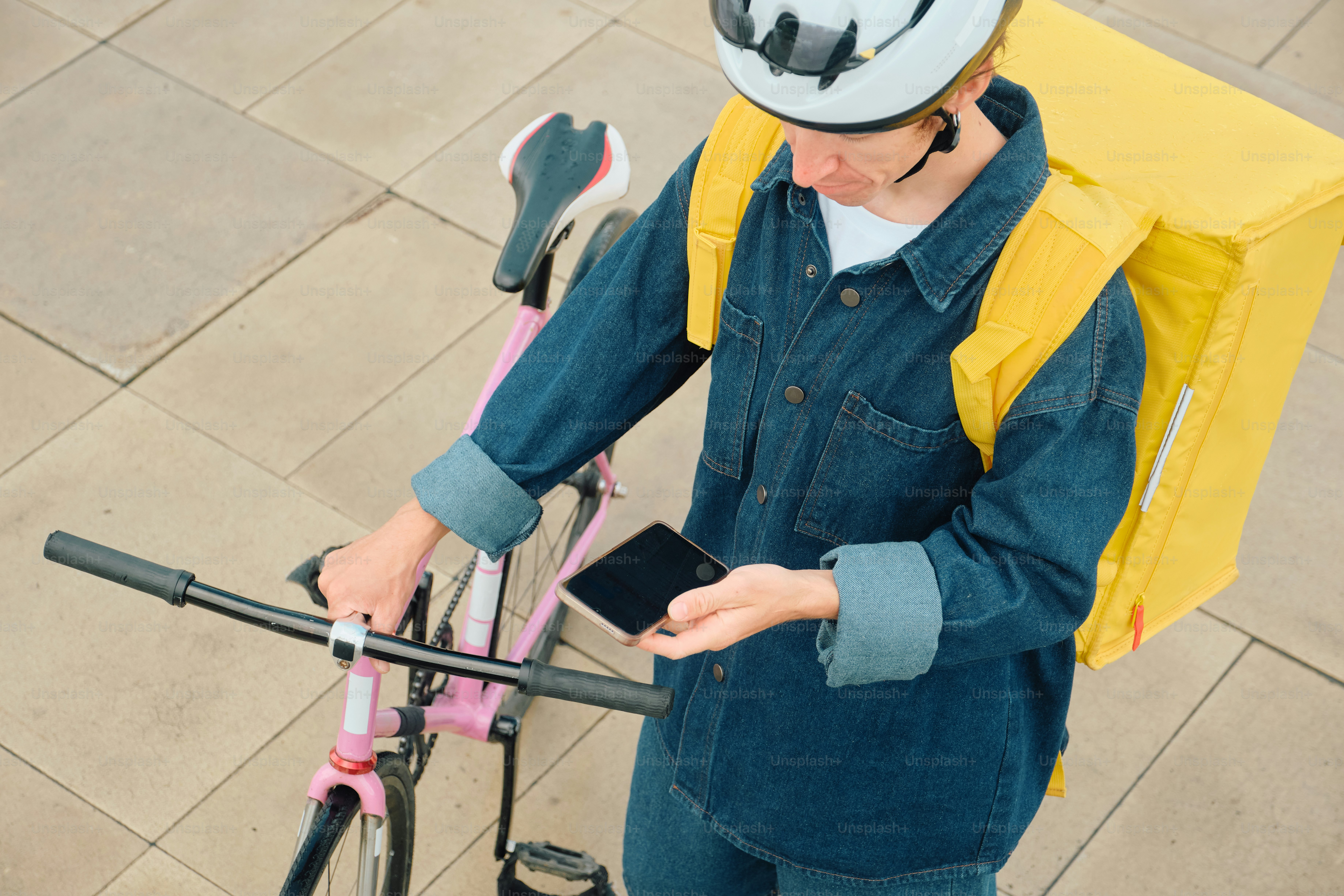 Conduttore che controlla lo smartphone con la bicicletta
