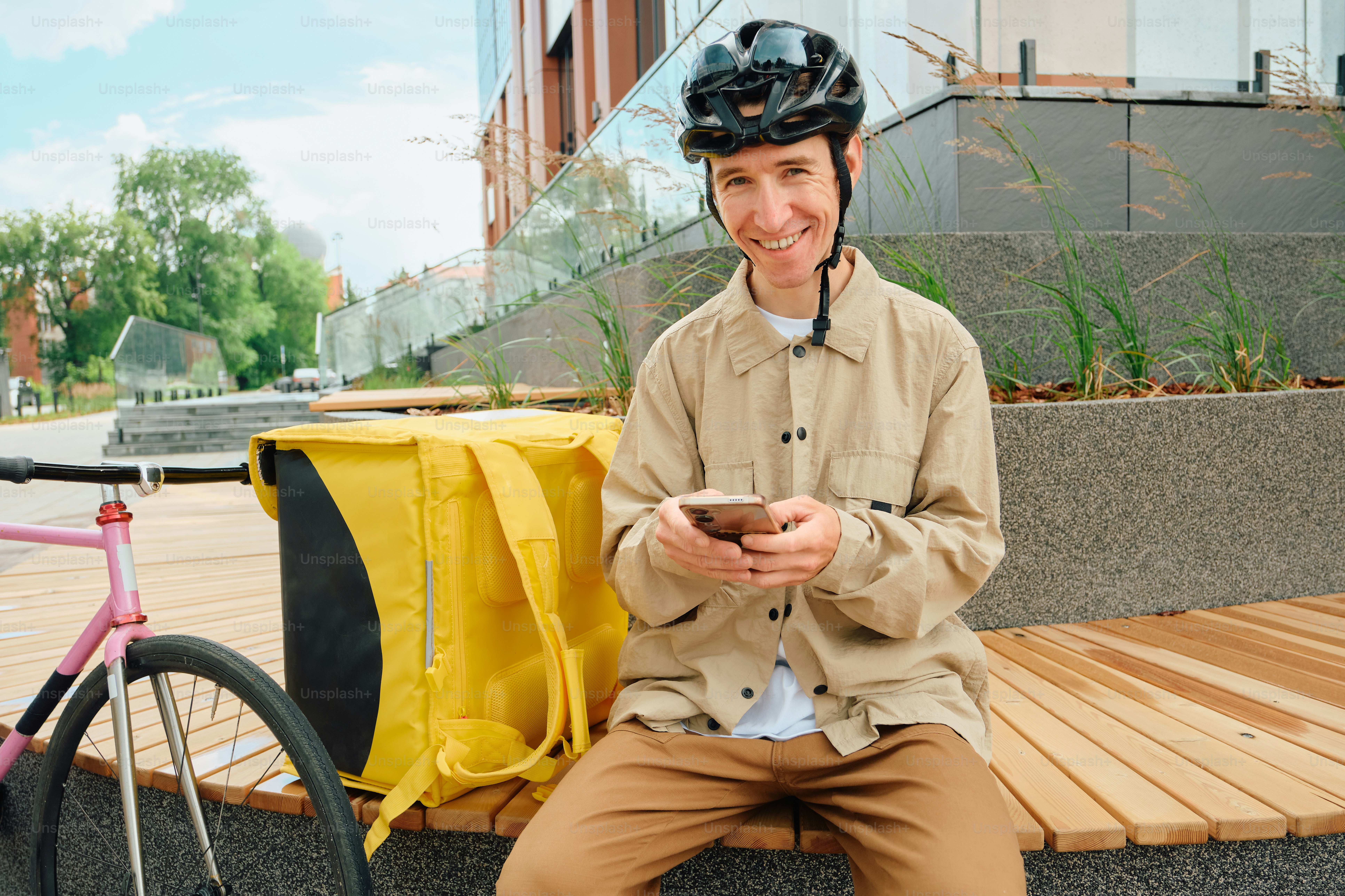 Food delivery rider resting with bike and phone