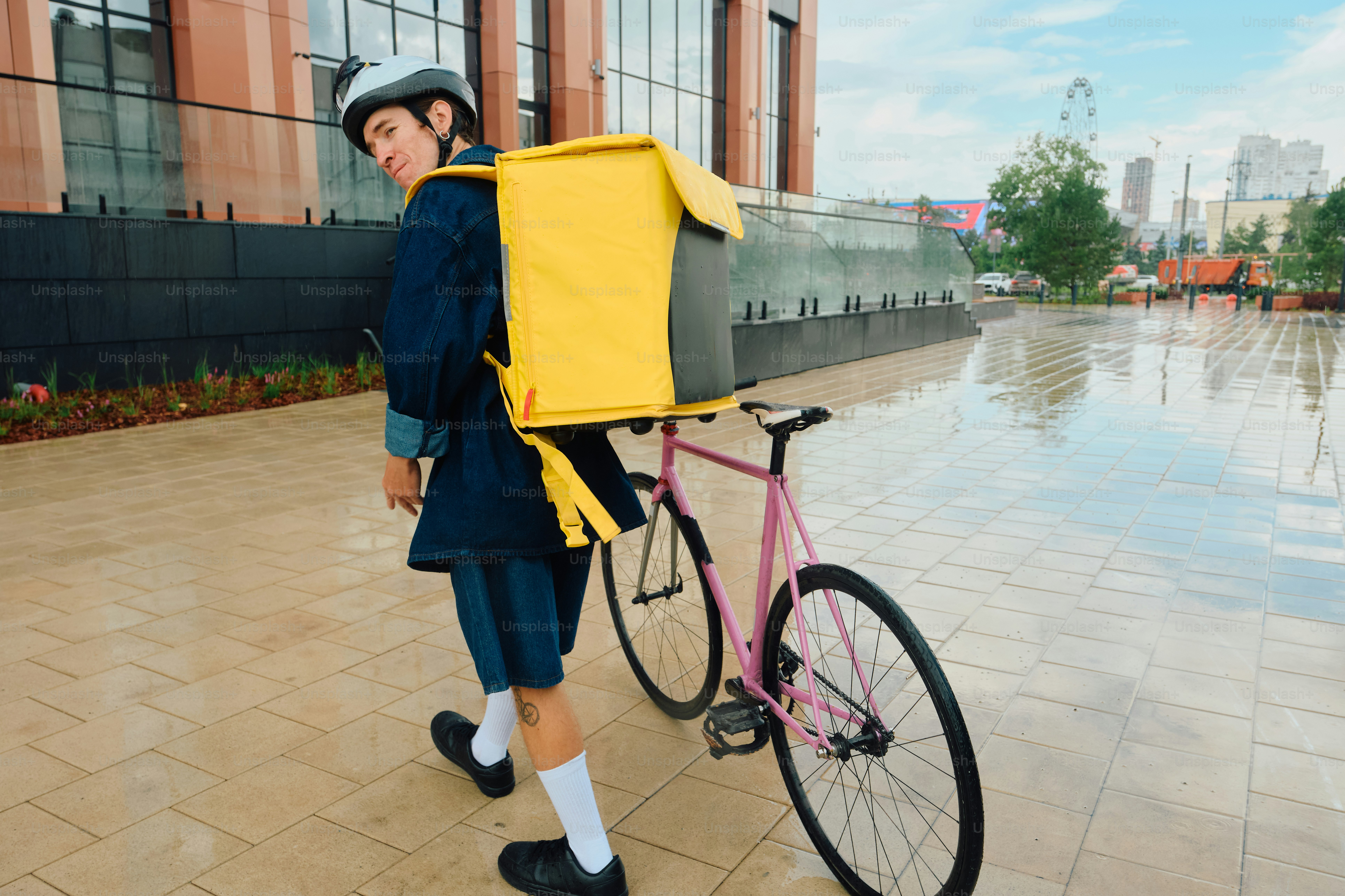 Food delivery rider with backpack and bicycle in city