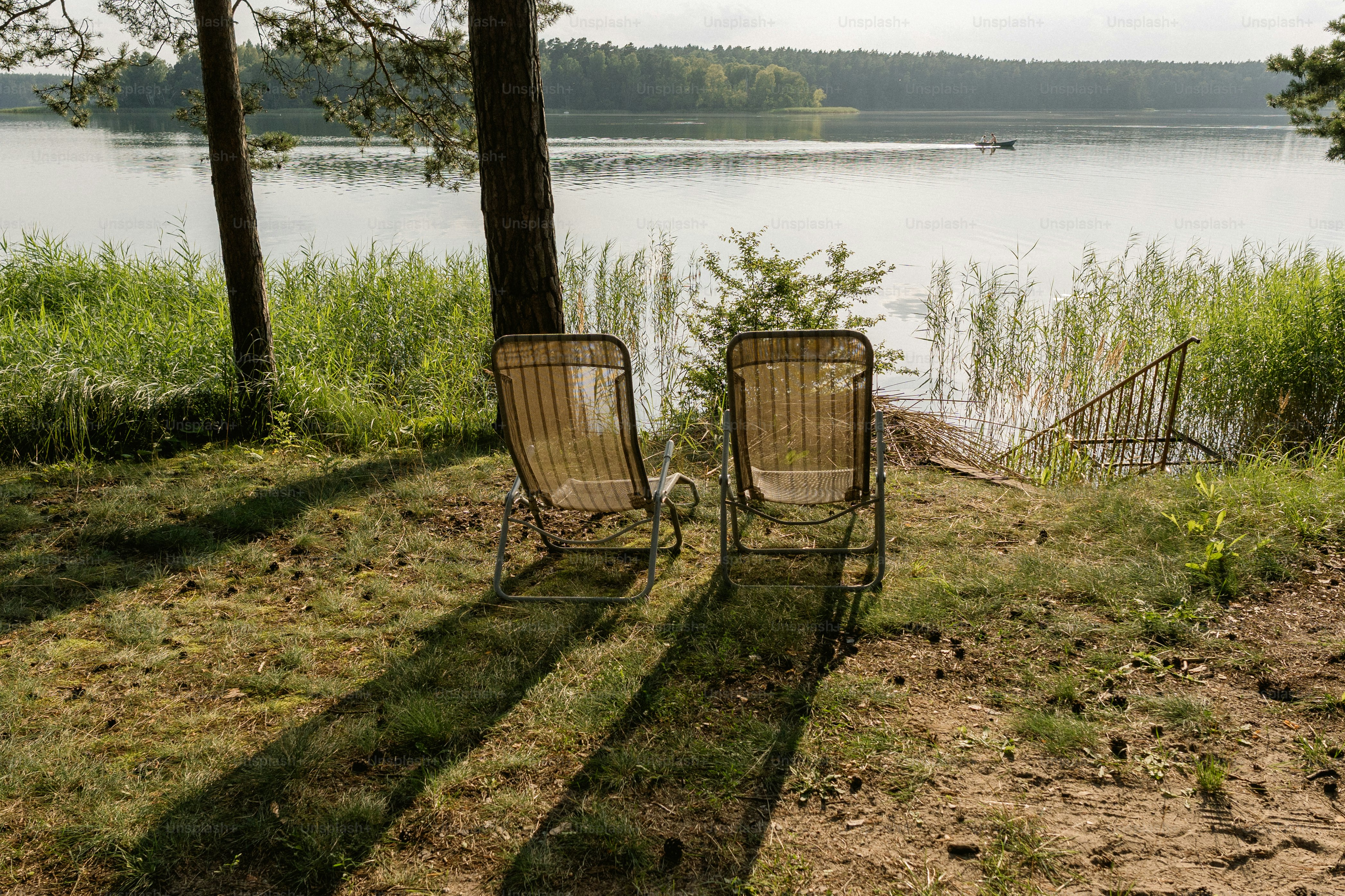 Two lounge chairs by a calm lake
