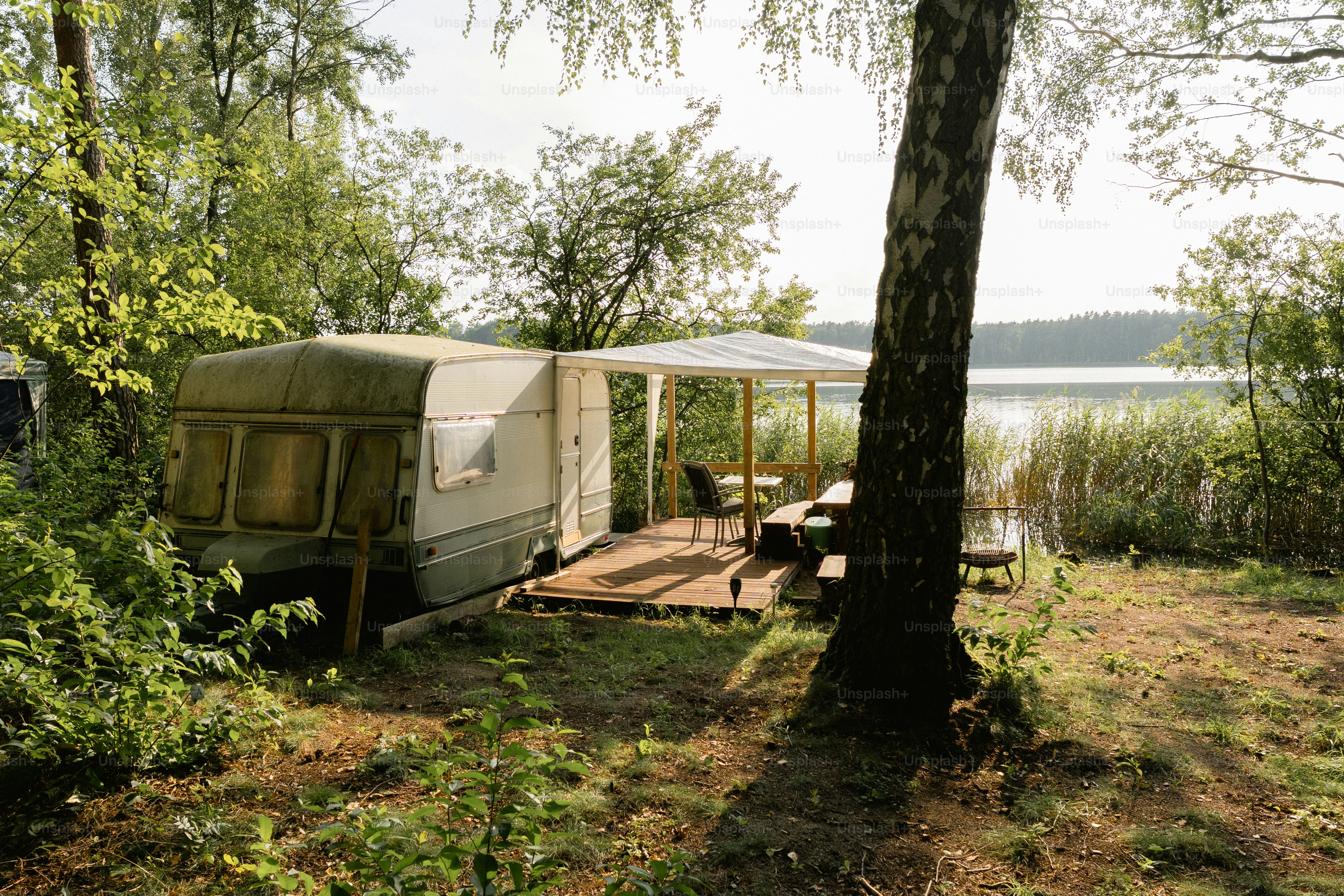 Caravan with awning and deck by a lake