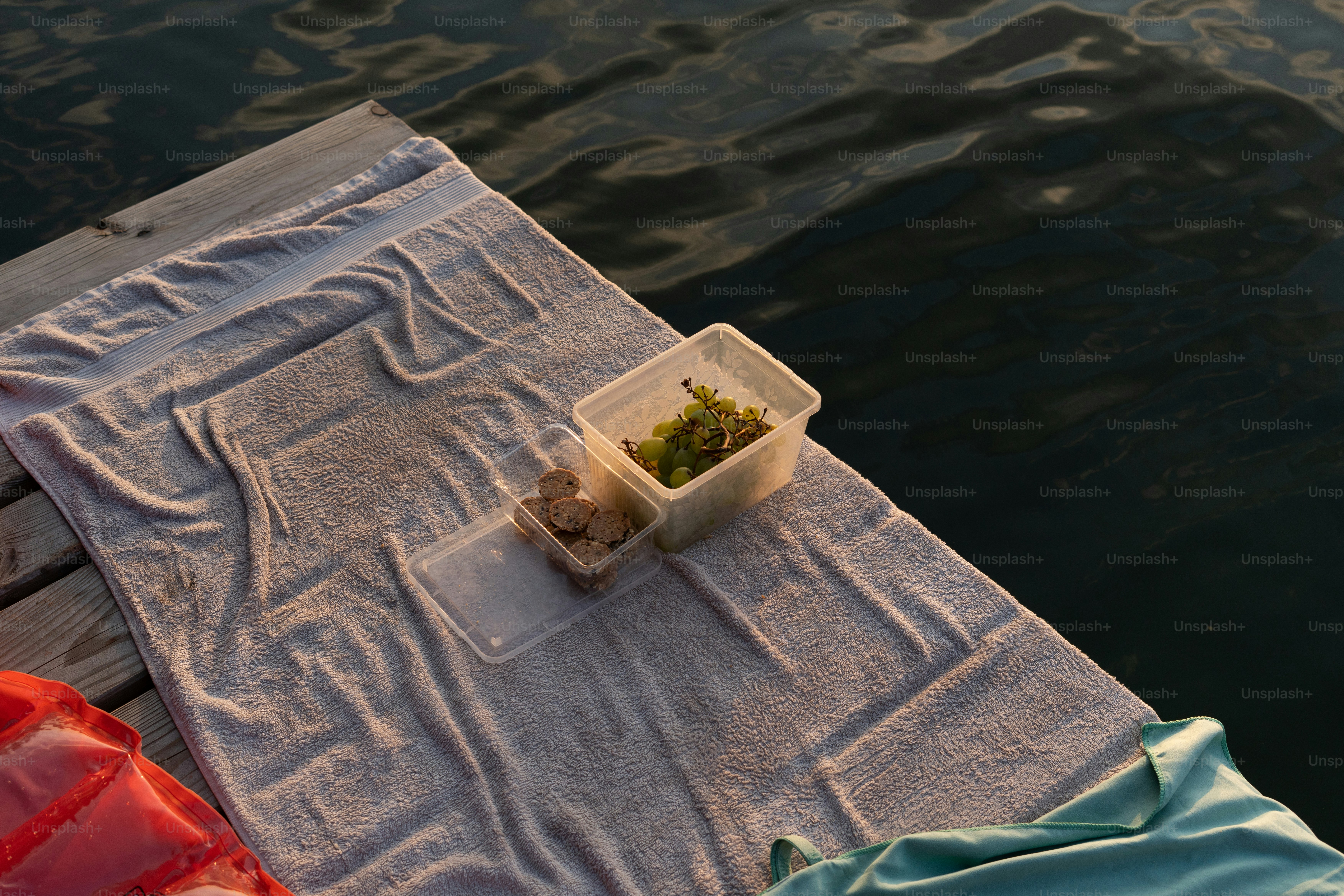 Towel and snacks on a wooden dock by the water