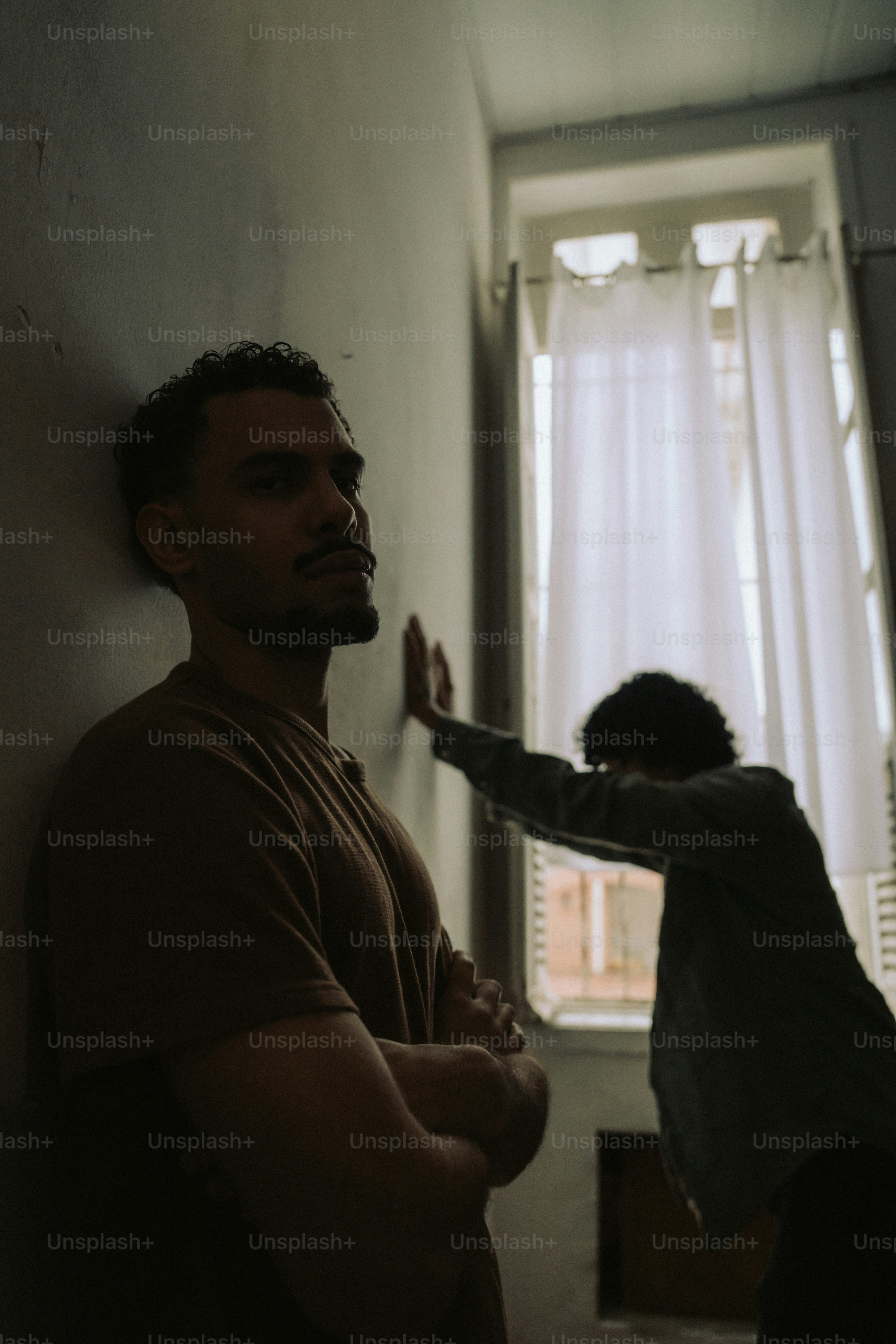 Two men standing in a dimly lit hallway