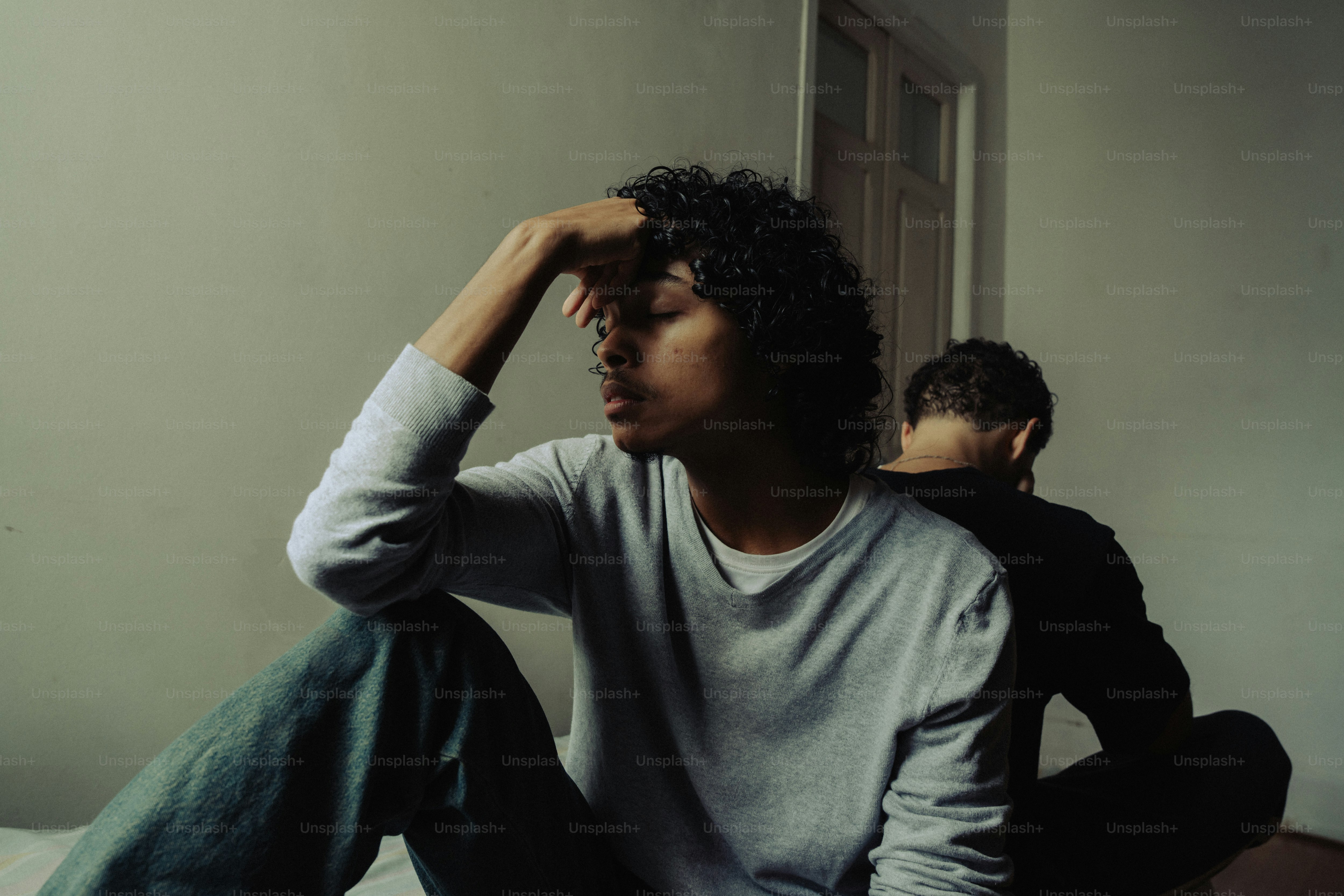 Stressed person with hand on head, another person nearby
