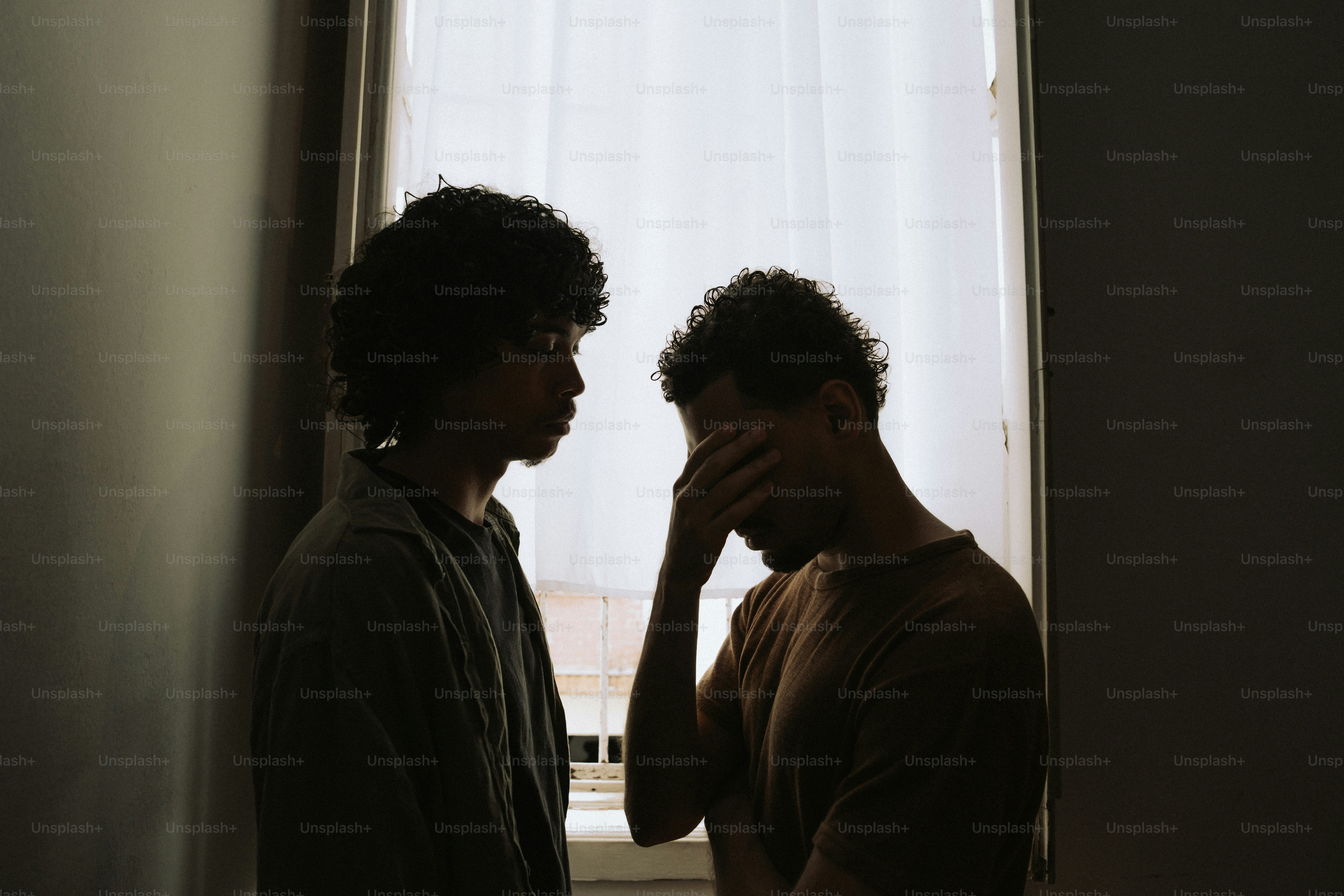 Silhouettes of two people, one comforting a distressed person