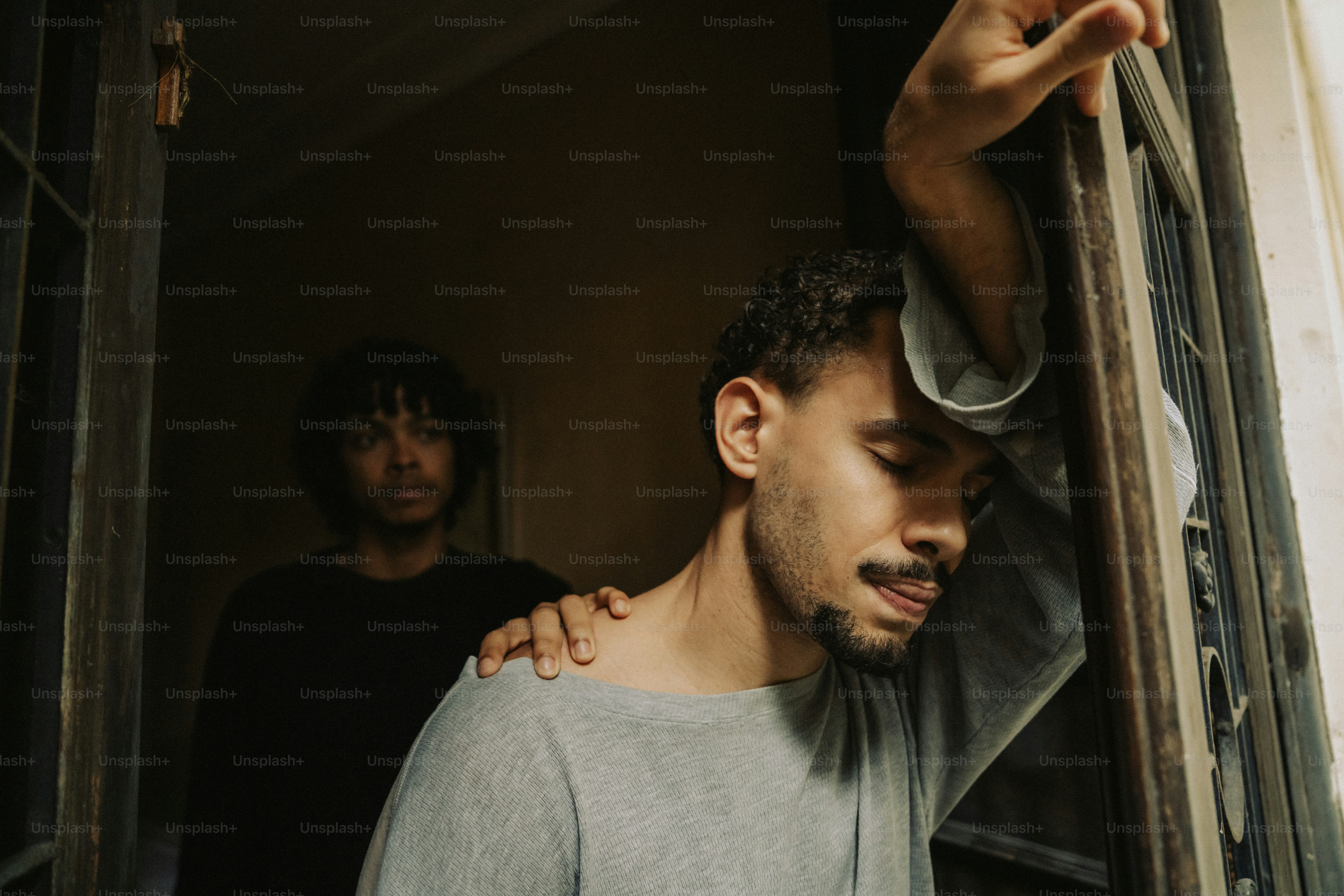 Man leaning against window, receiving comfort
