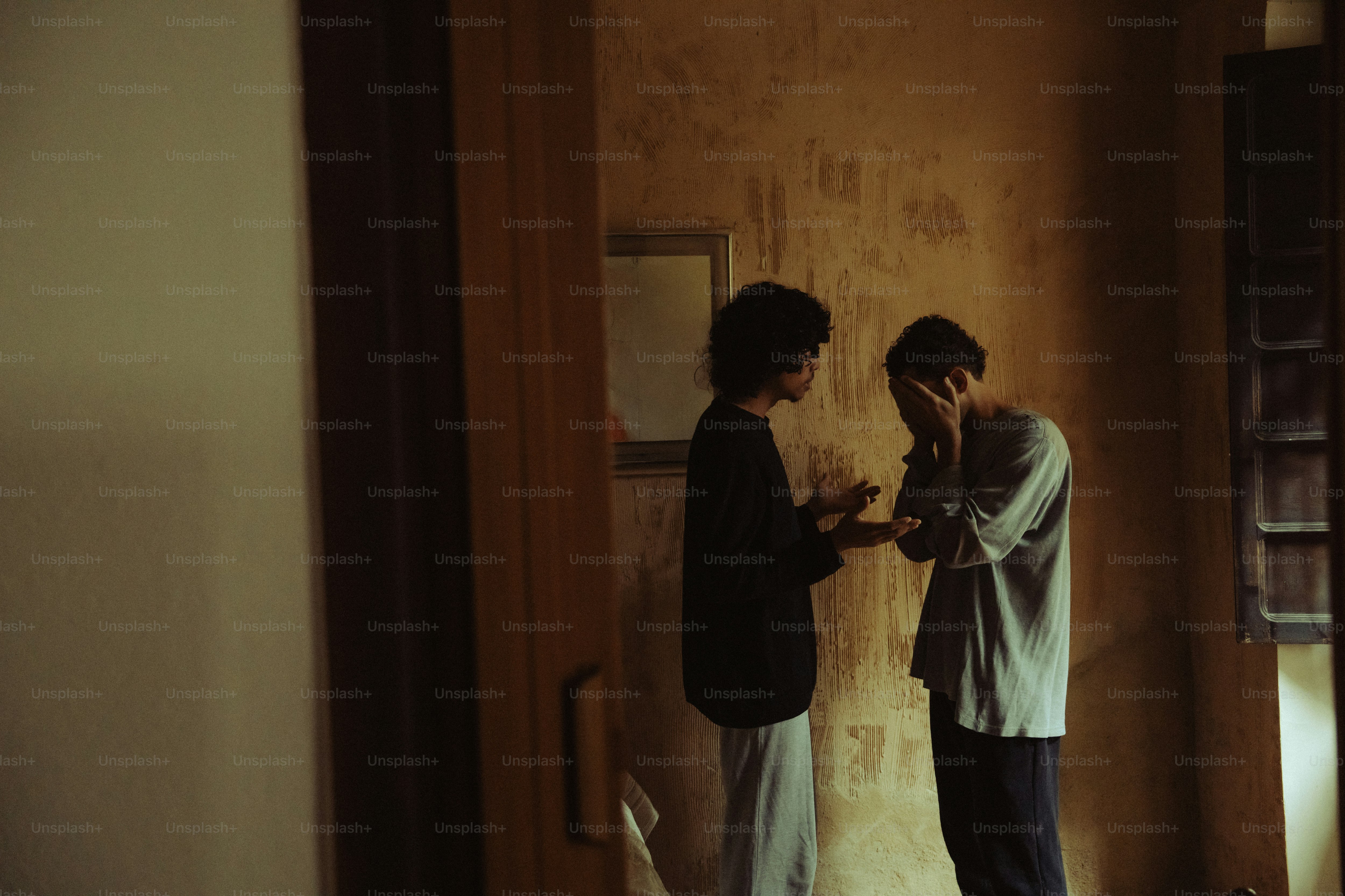 Person comforting another person covering their face