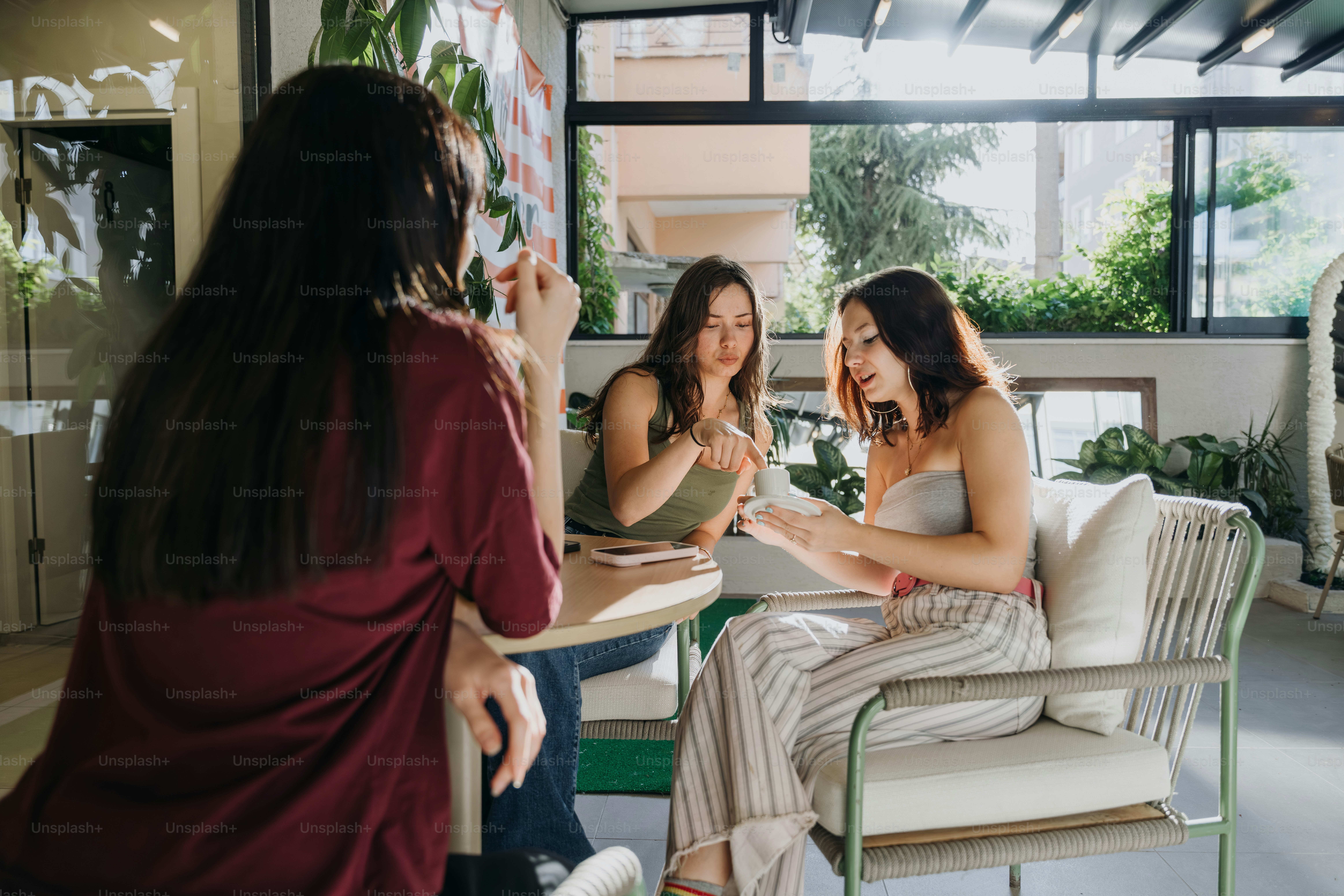 Drei Frauen unterhalten sich an einem Cafétisch