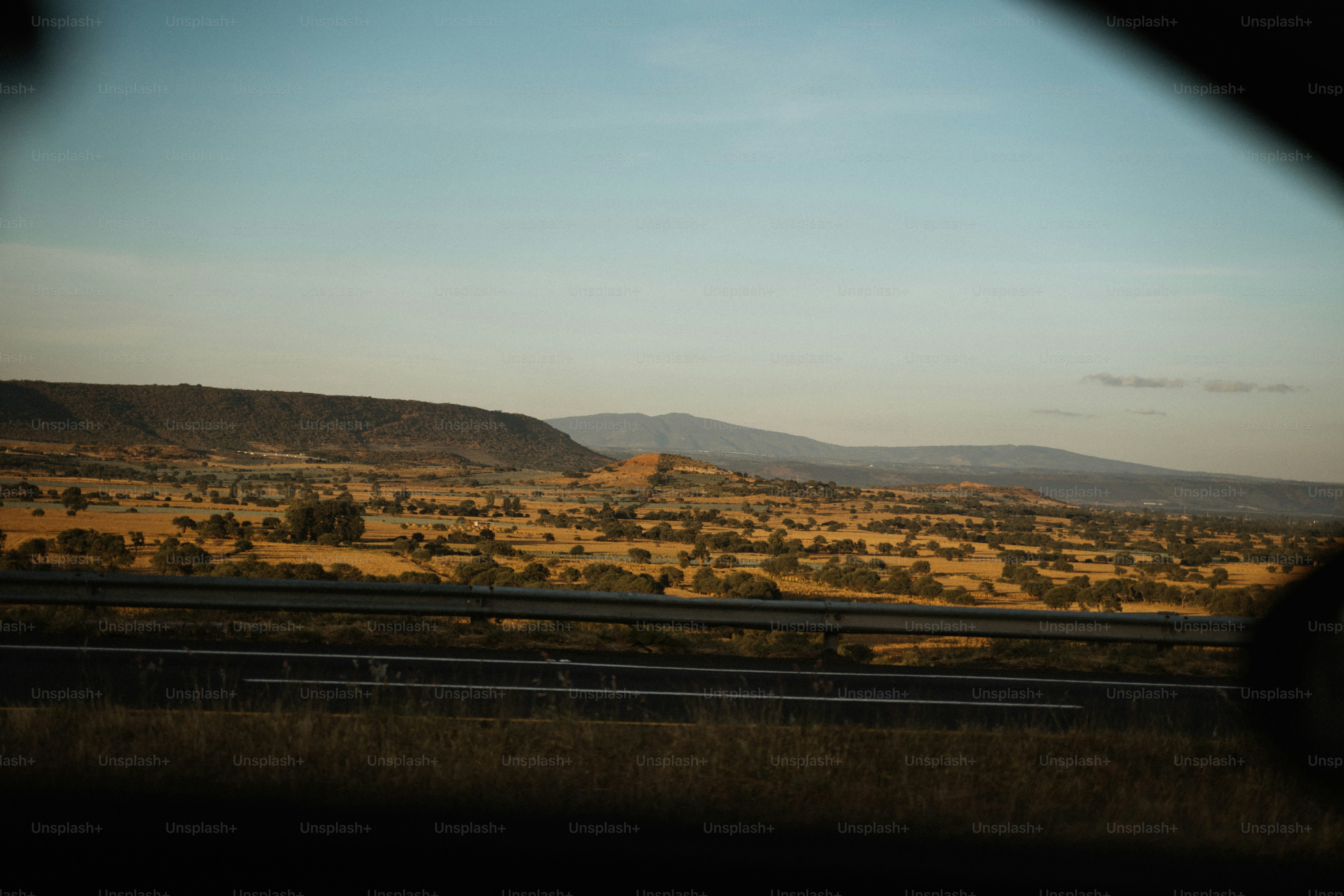 Vast dry landscape with distant hills and highway