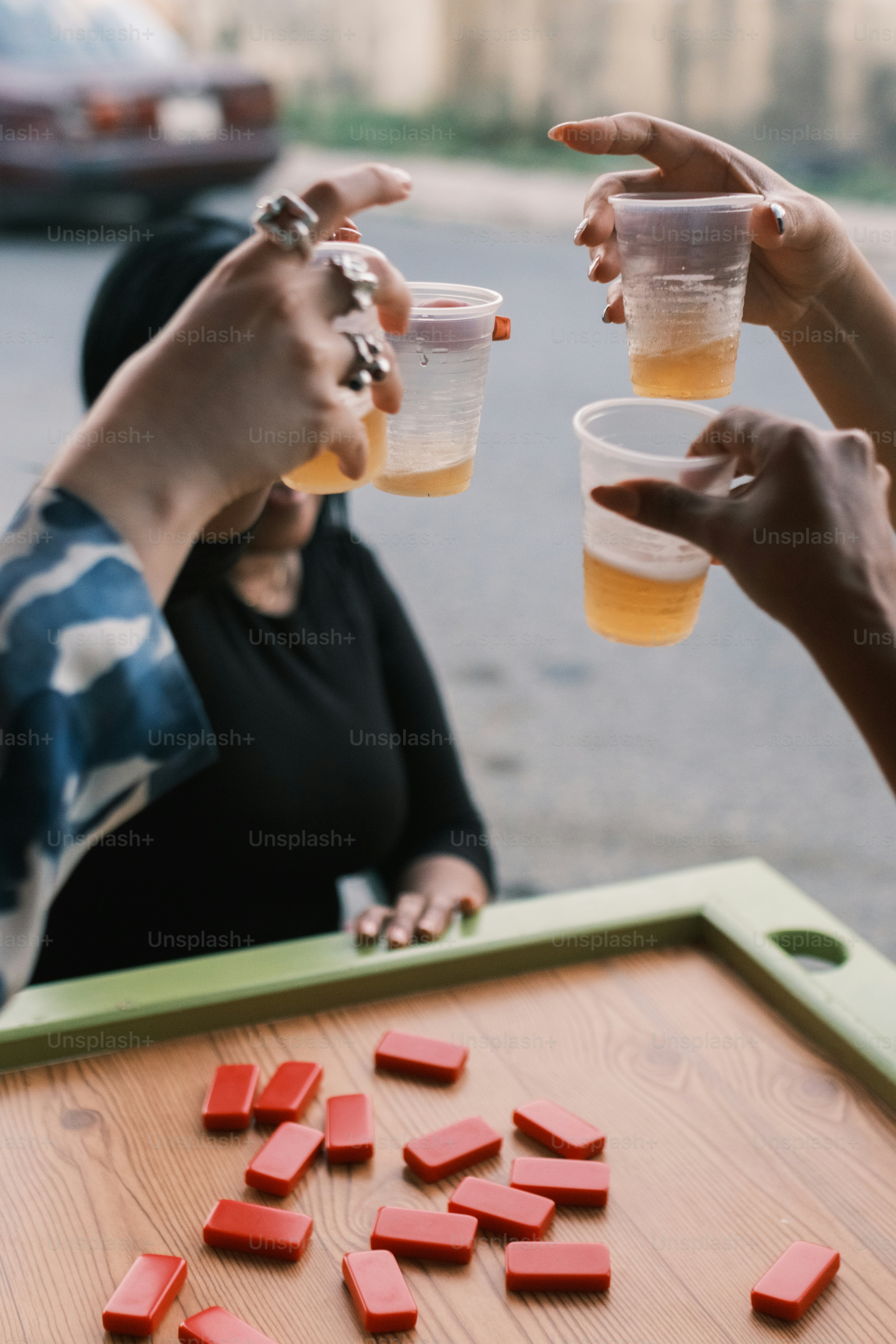 Brindando bebidas sobre uma mesa de dominós vermelhos