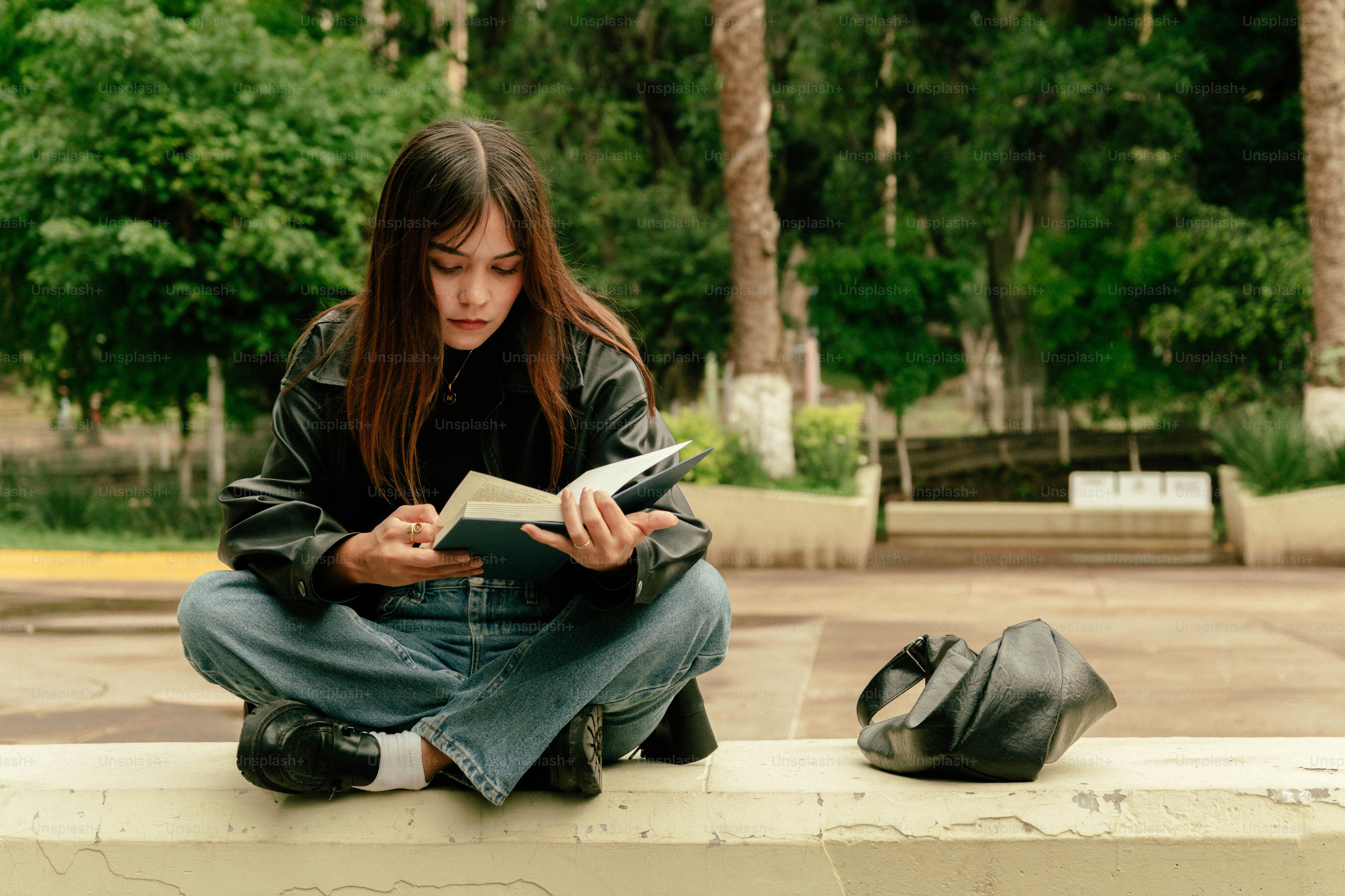 Young woman reading a book while sitting outdoors