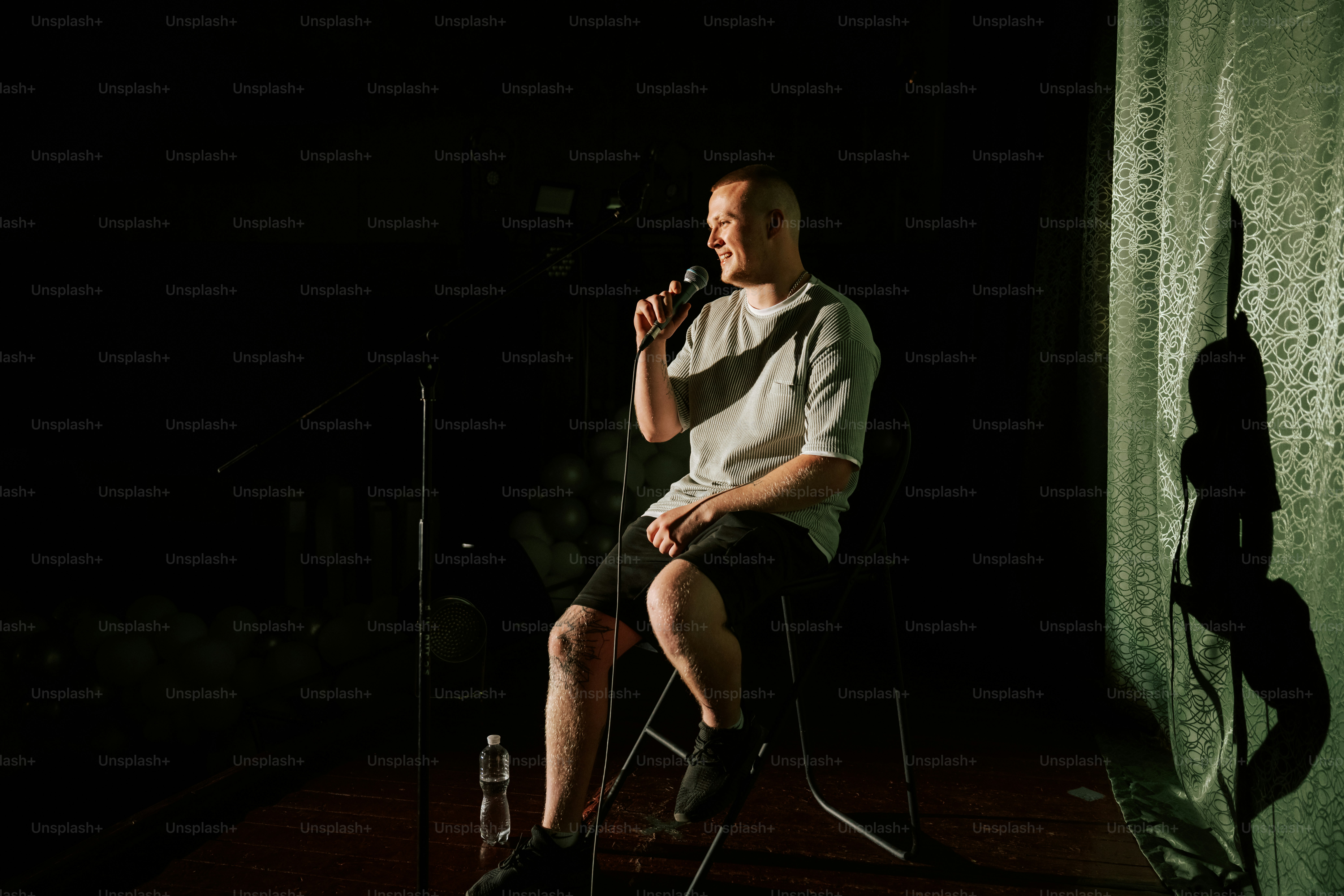 Stand-up-Comedian tritt auf der Bühne auf und hält ein Mikrofon