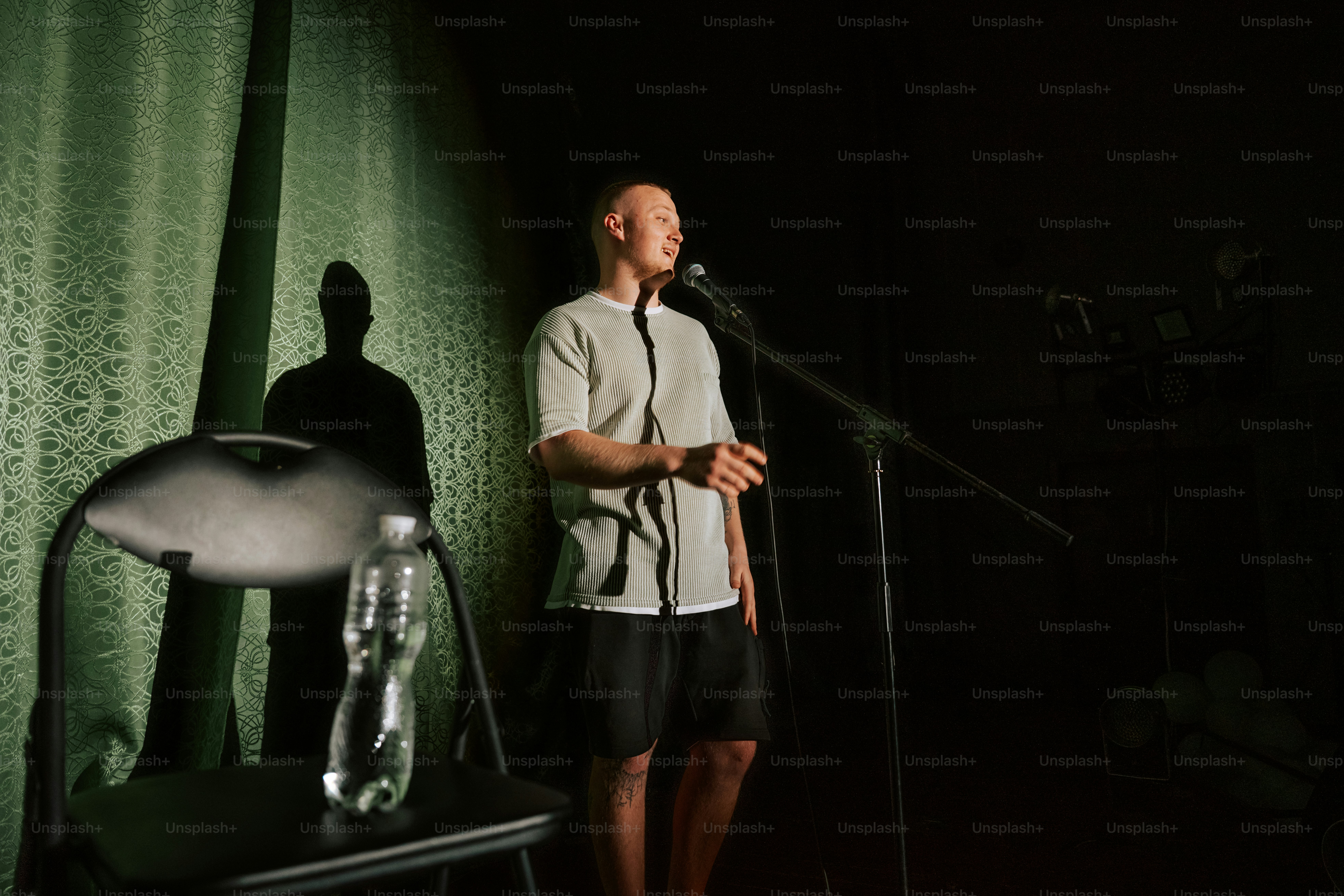 Man speaking into microphone on dark stage photo – Event Image on Unsplash