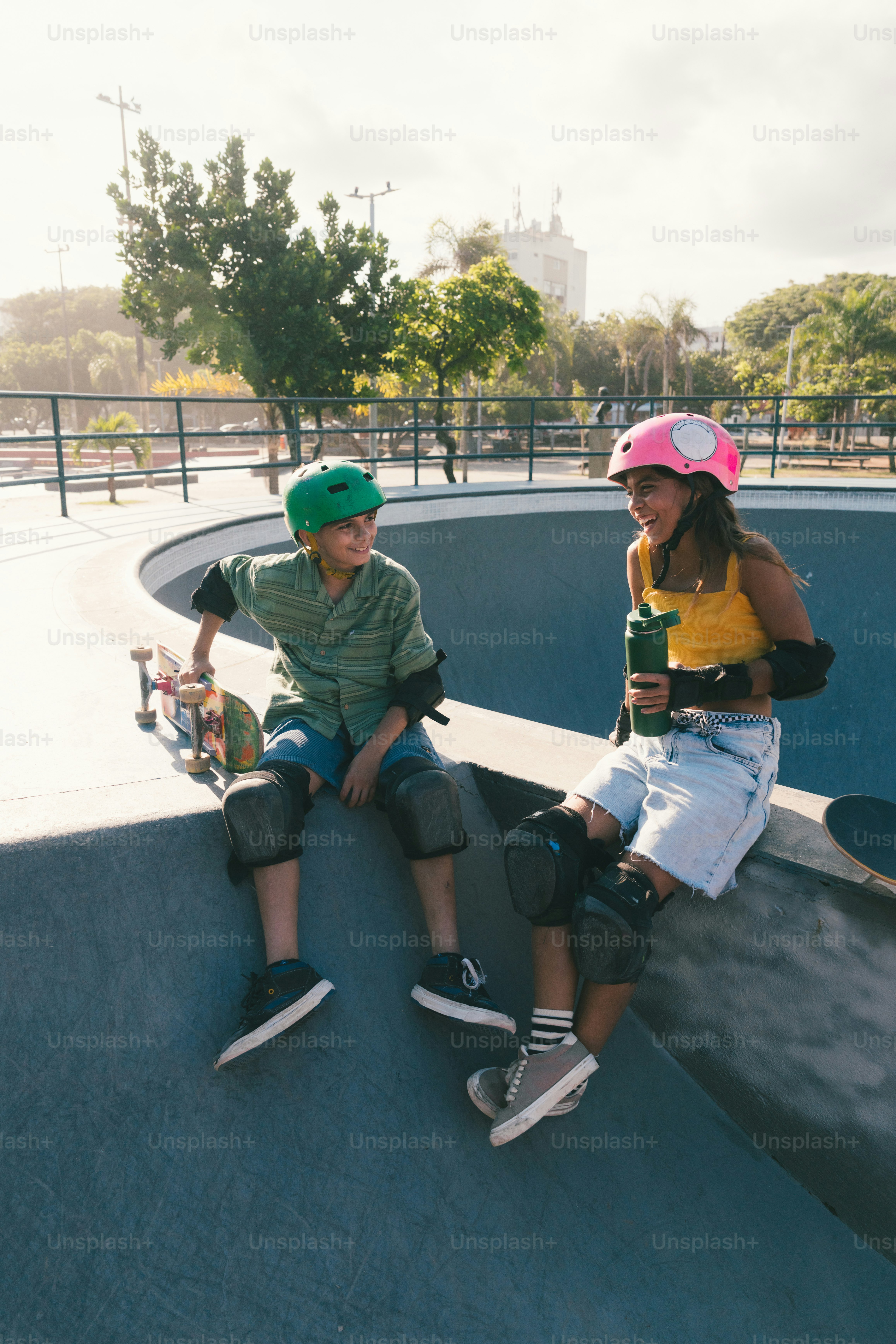 Young skateboarders wearing helmets relaxing in a skate park