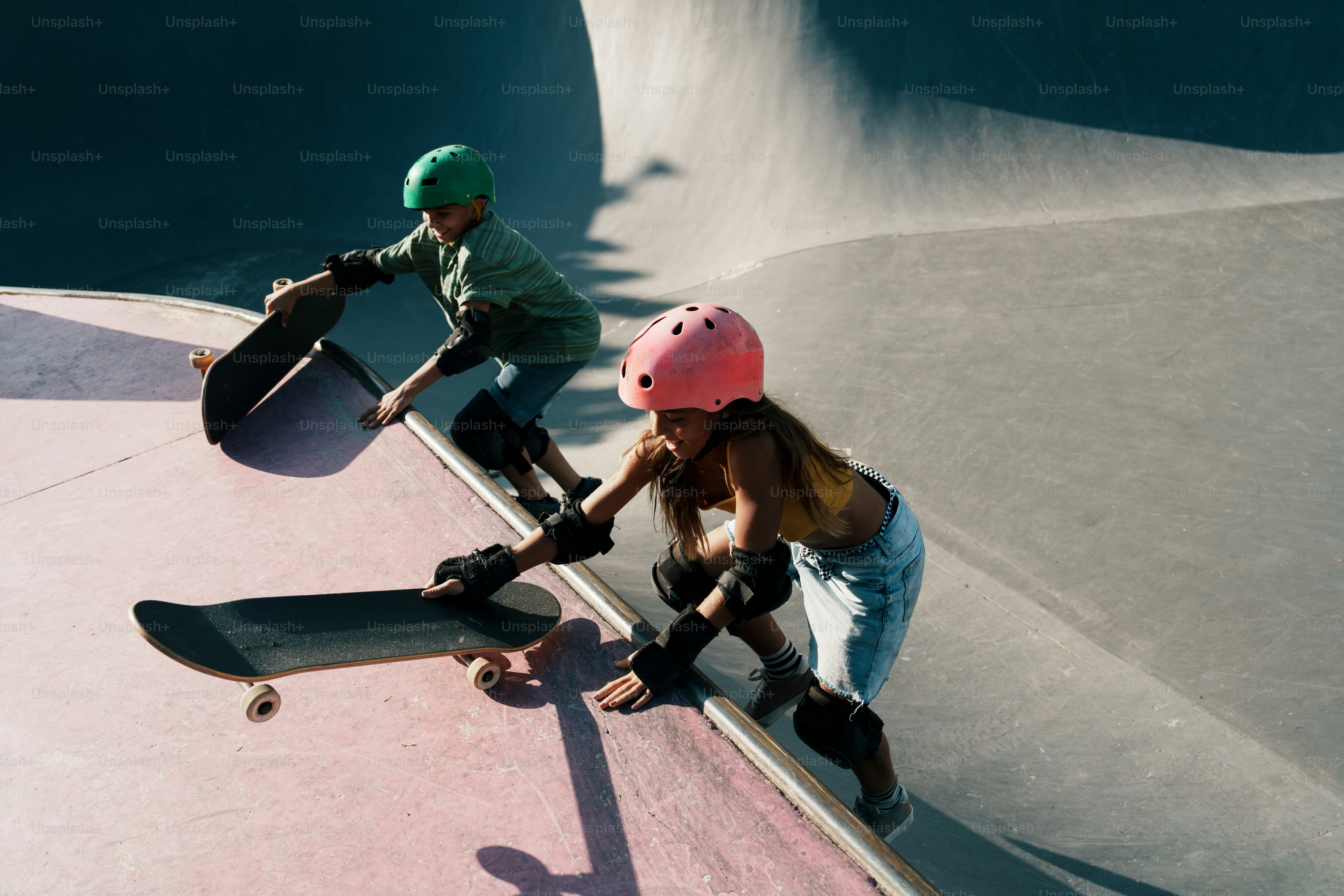 Kids with skateboards climbing a skate park ramp