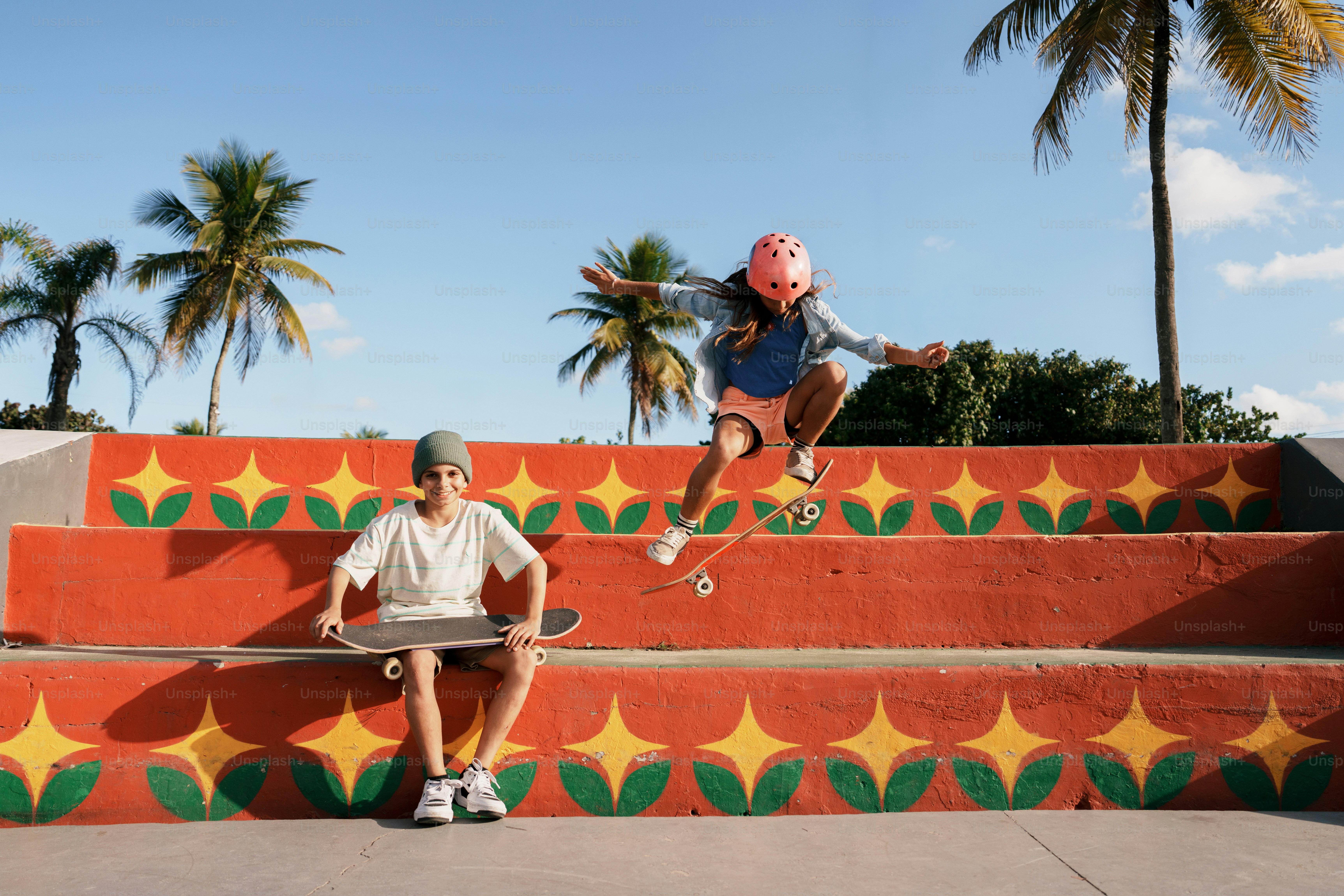 Skateboarder jumping over colorful stairs, friend watching