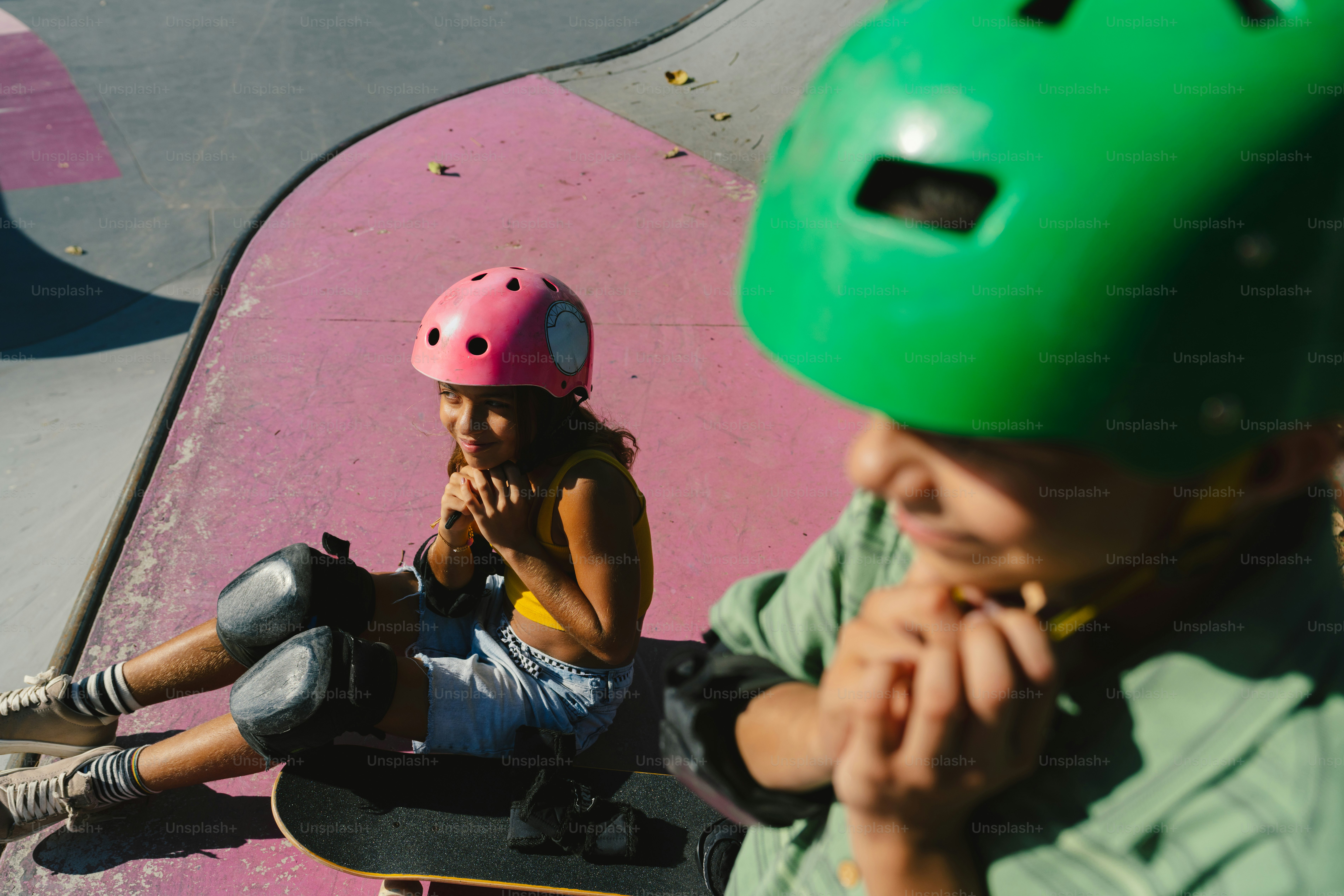 Kids adjusting helmets and pads at skate park