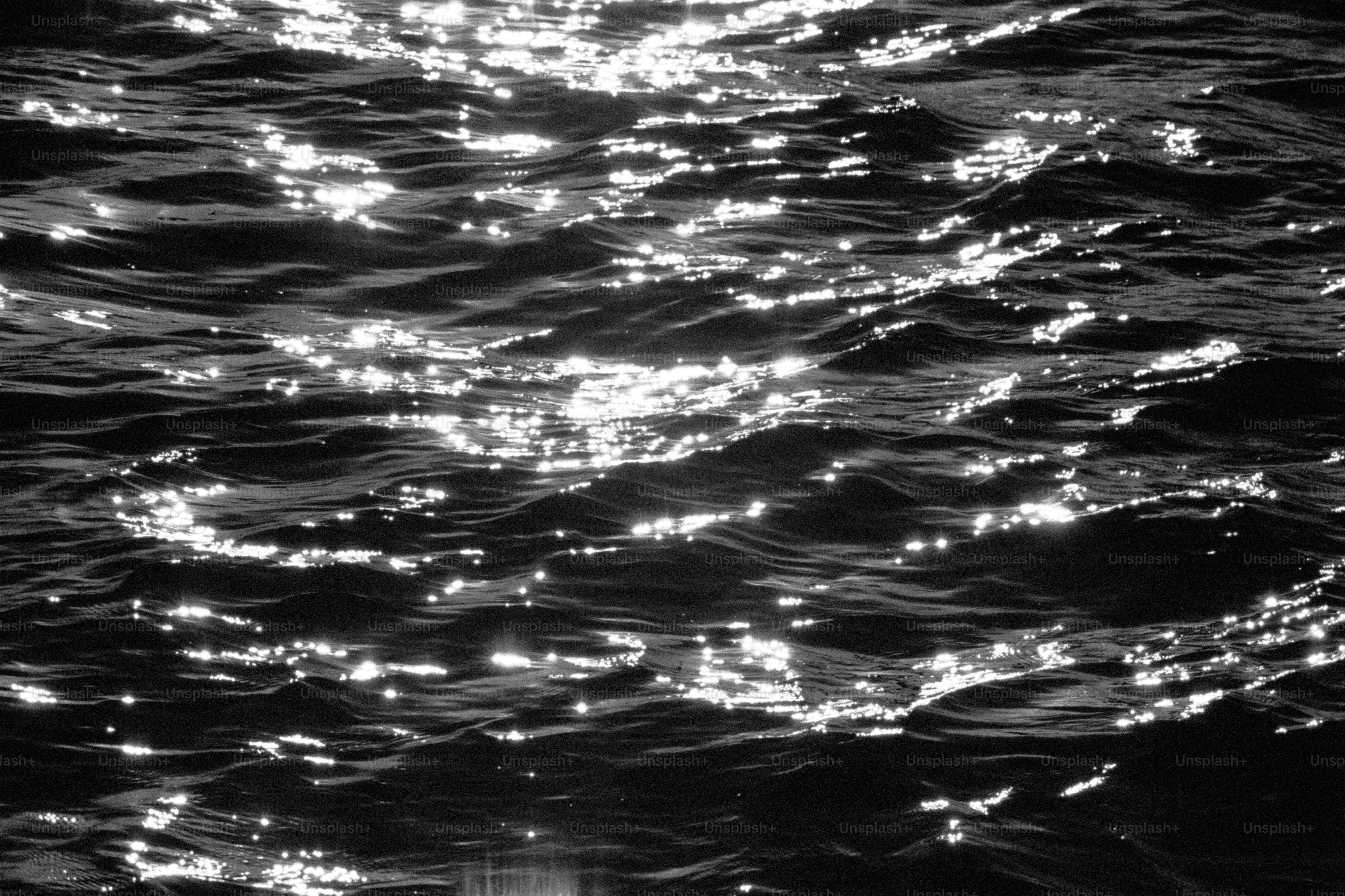 Sunlight sparkling on dark water surface