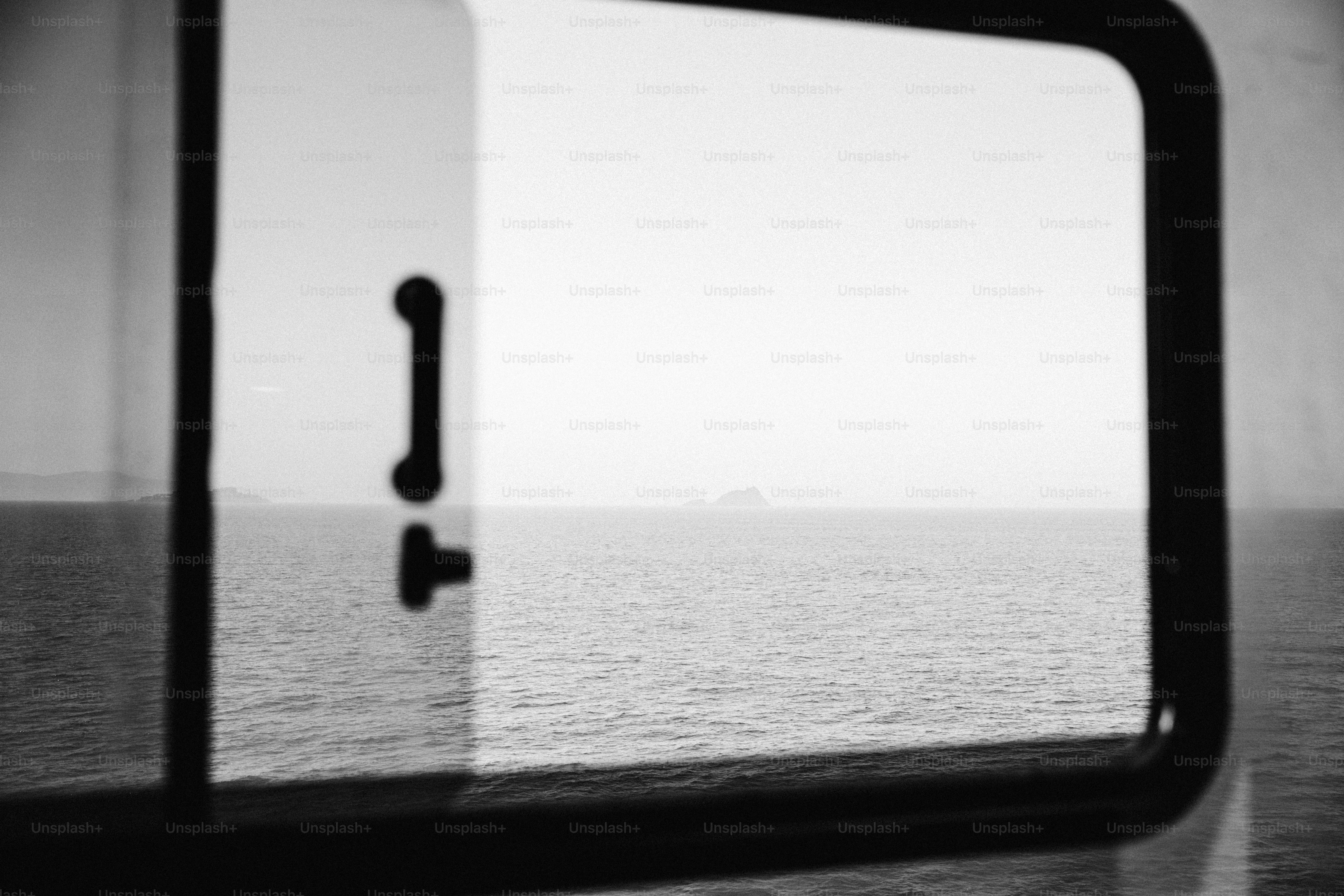Distant land across ocean through boat window