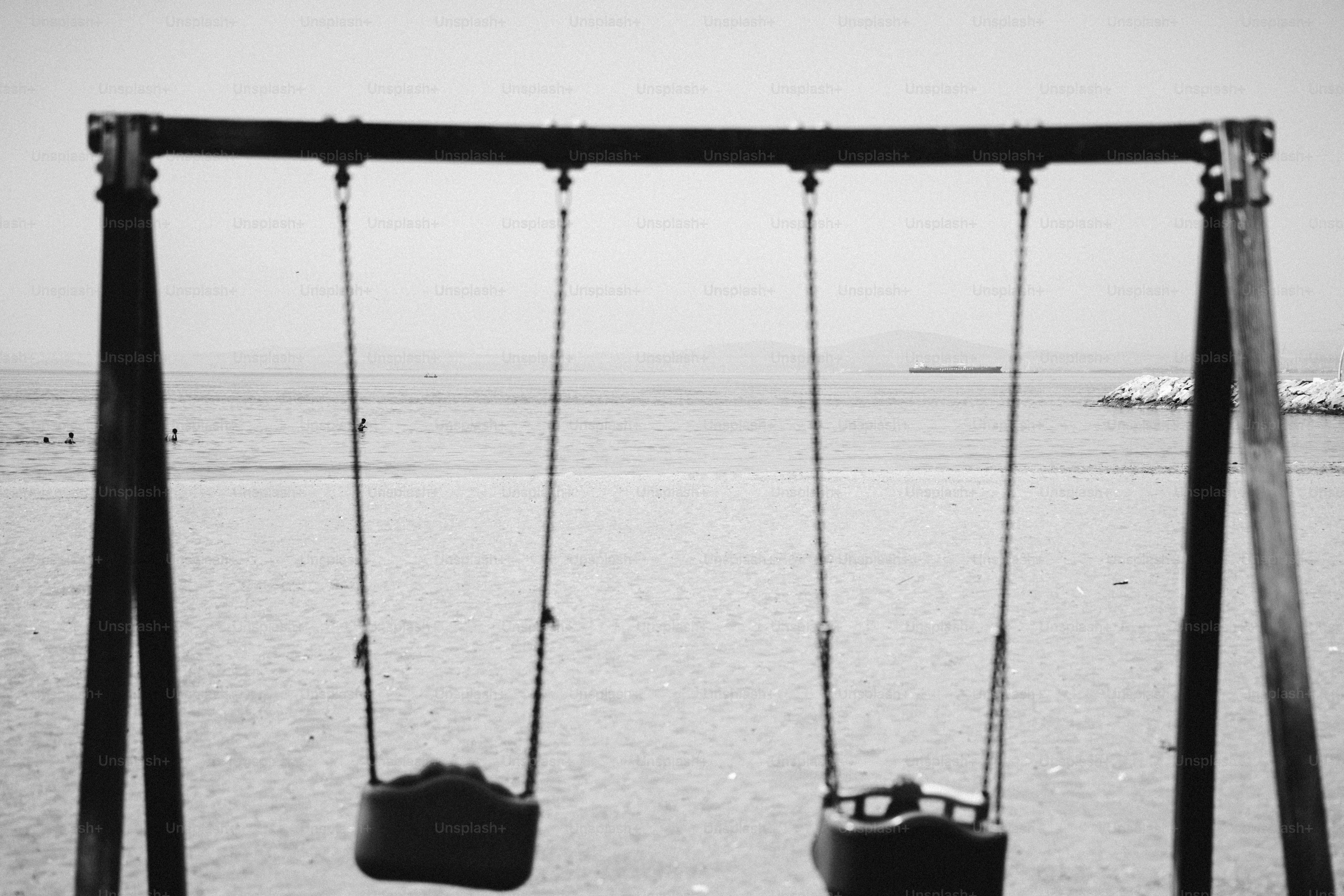 Black and white empty swings by the water