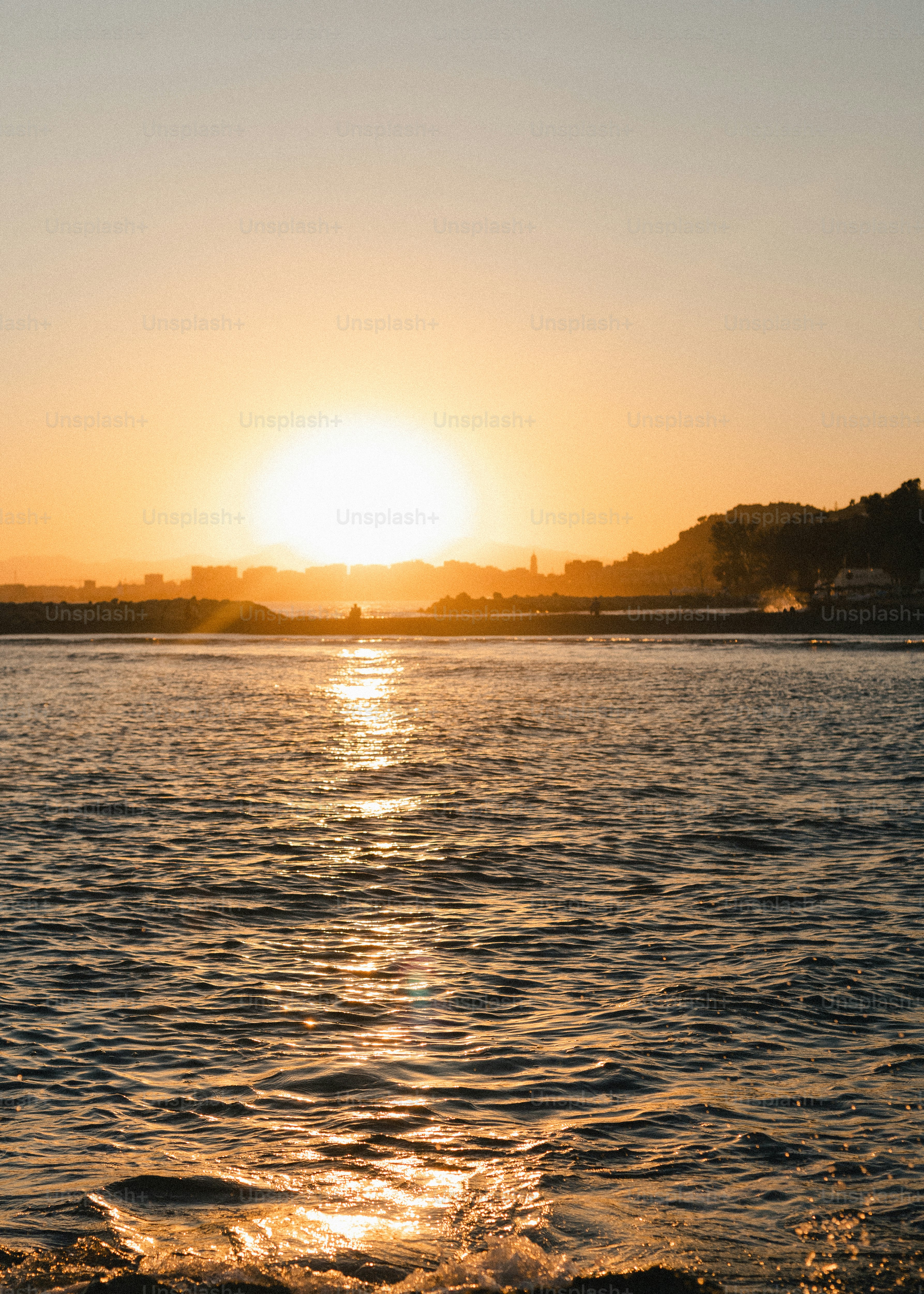 黄金色の夏の夕焼けが穏やかな海に映る