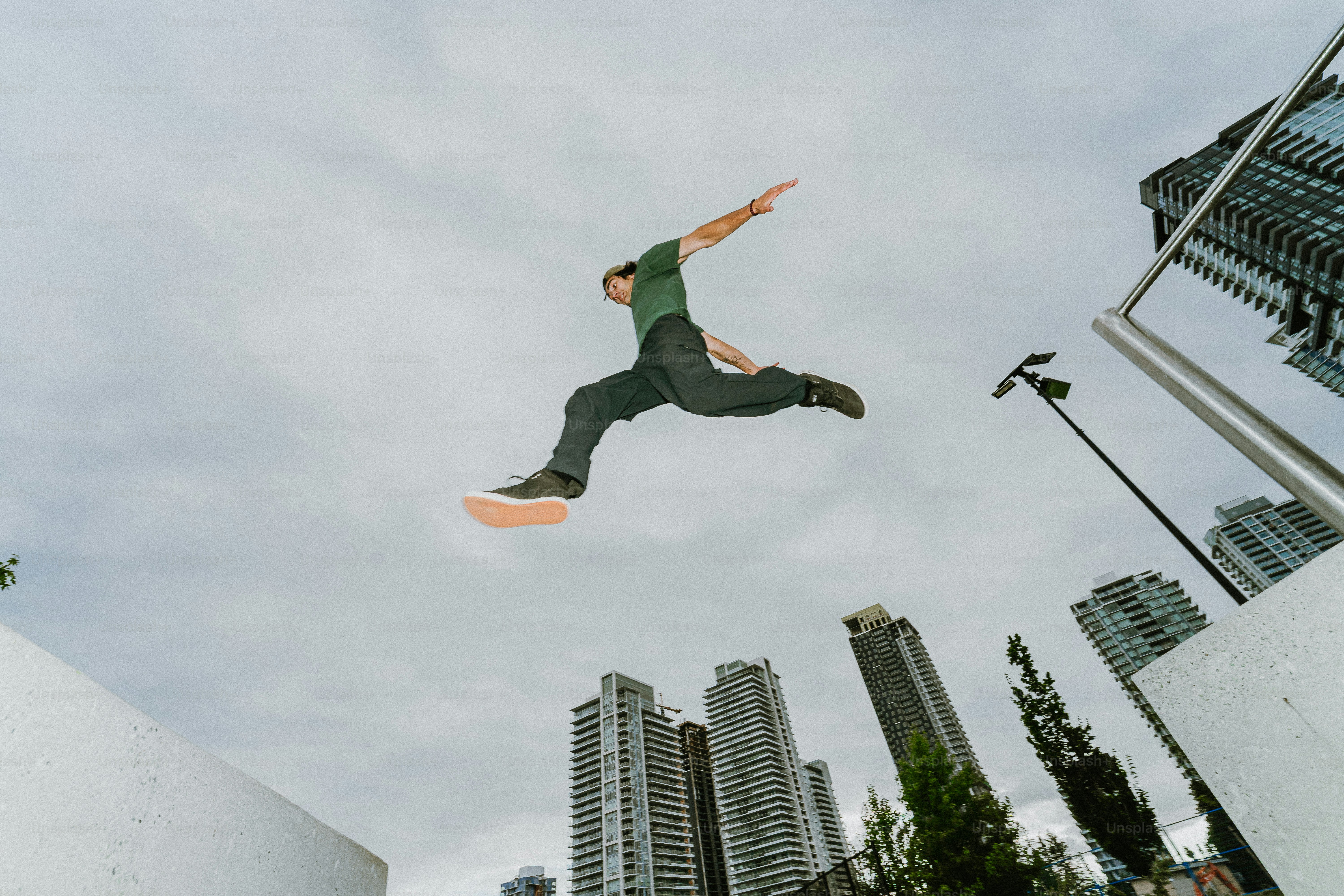 Parkour athlete jumping high above city buildings