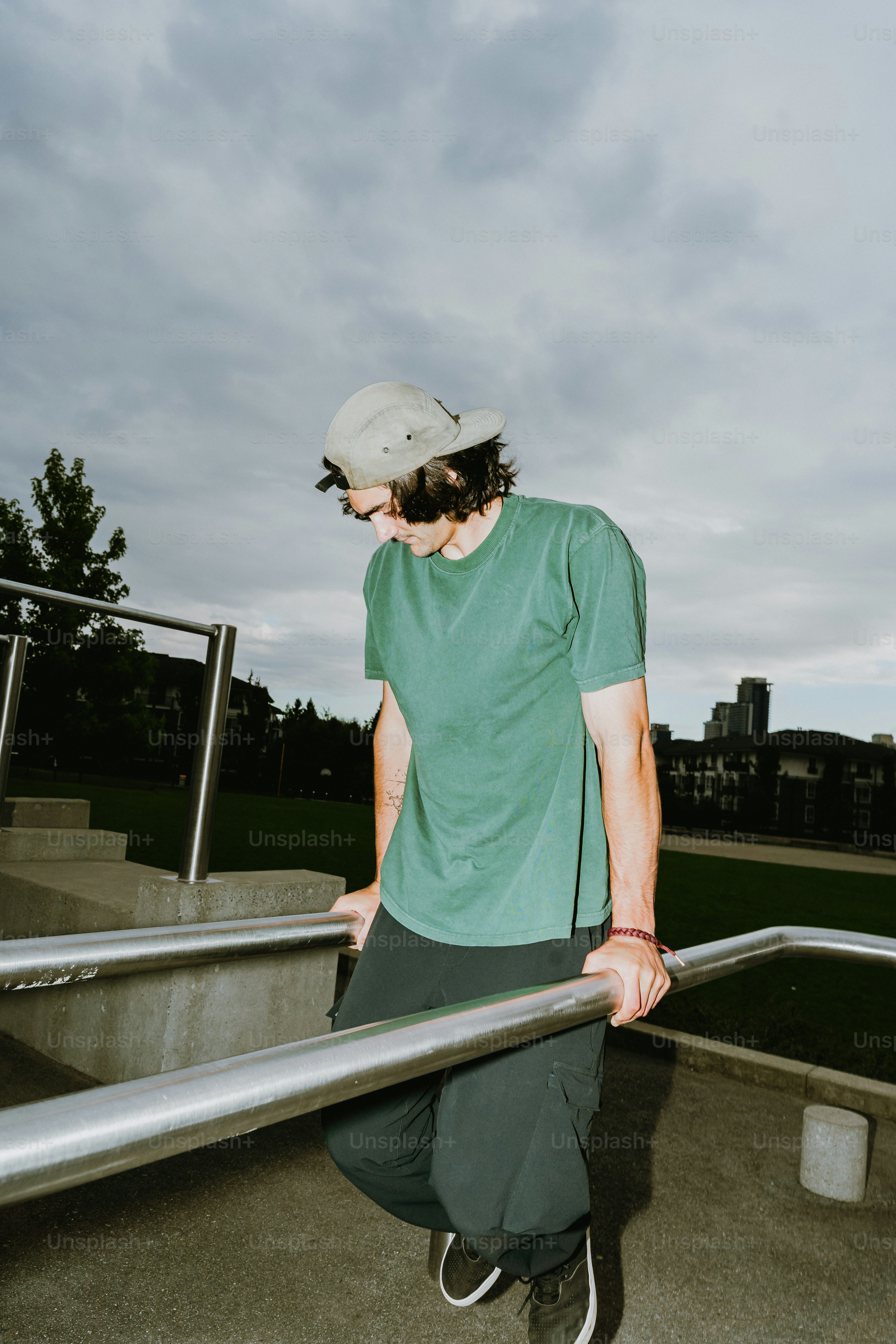 Young man leaning on metal railings in a park