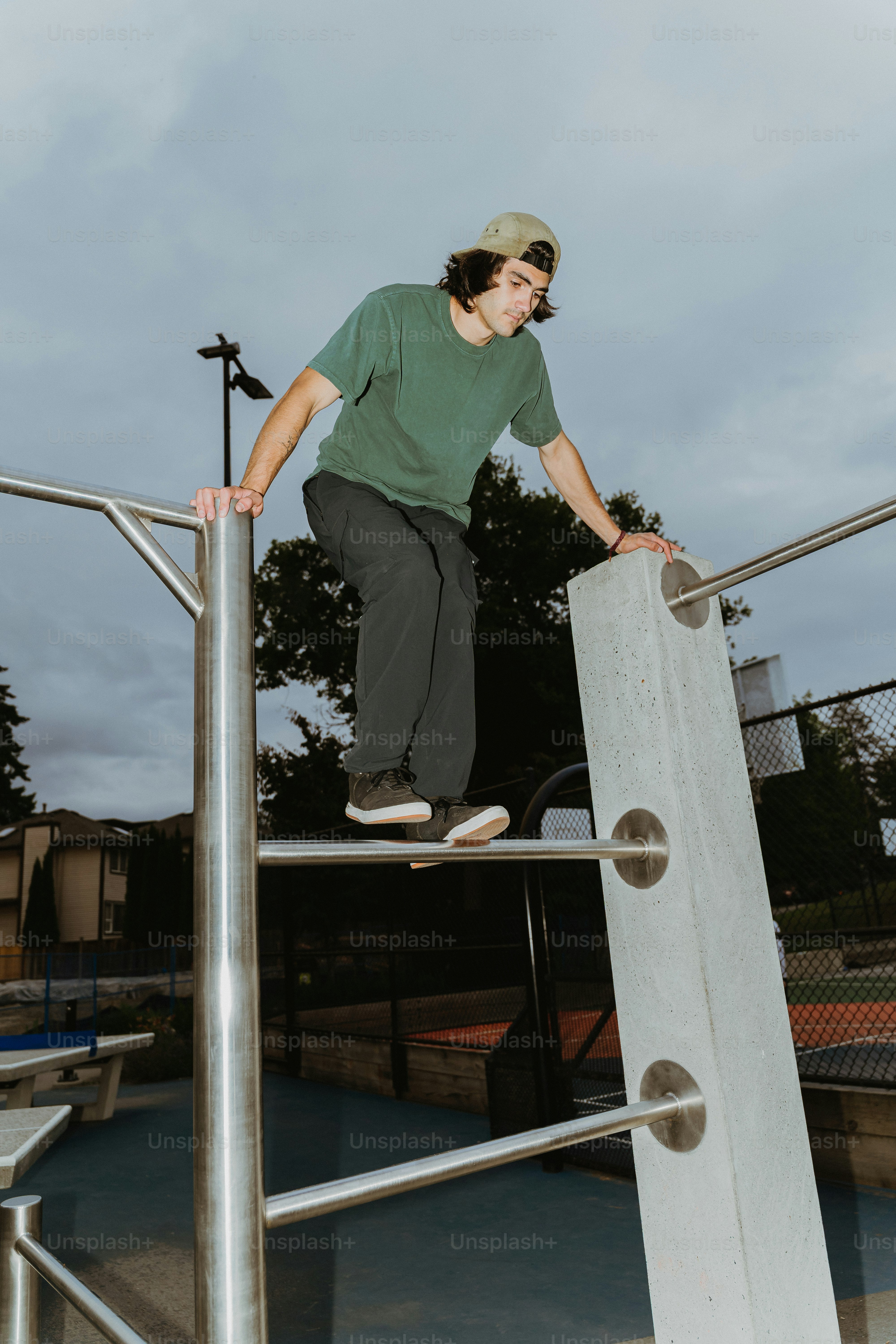 Young man balancing on metal bars outdoors