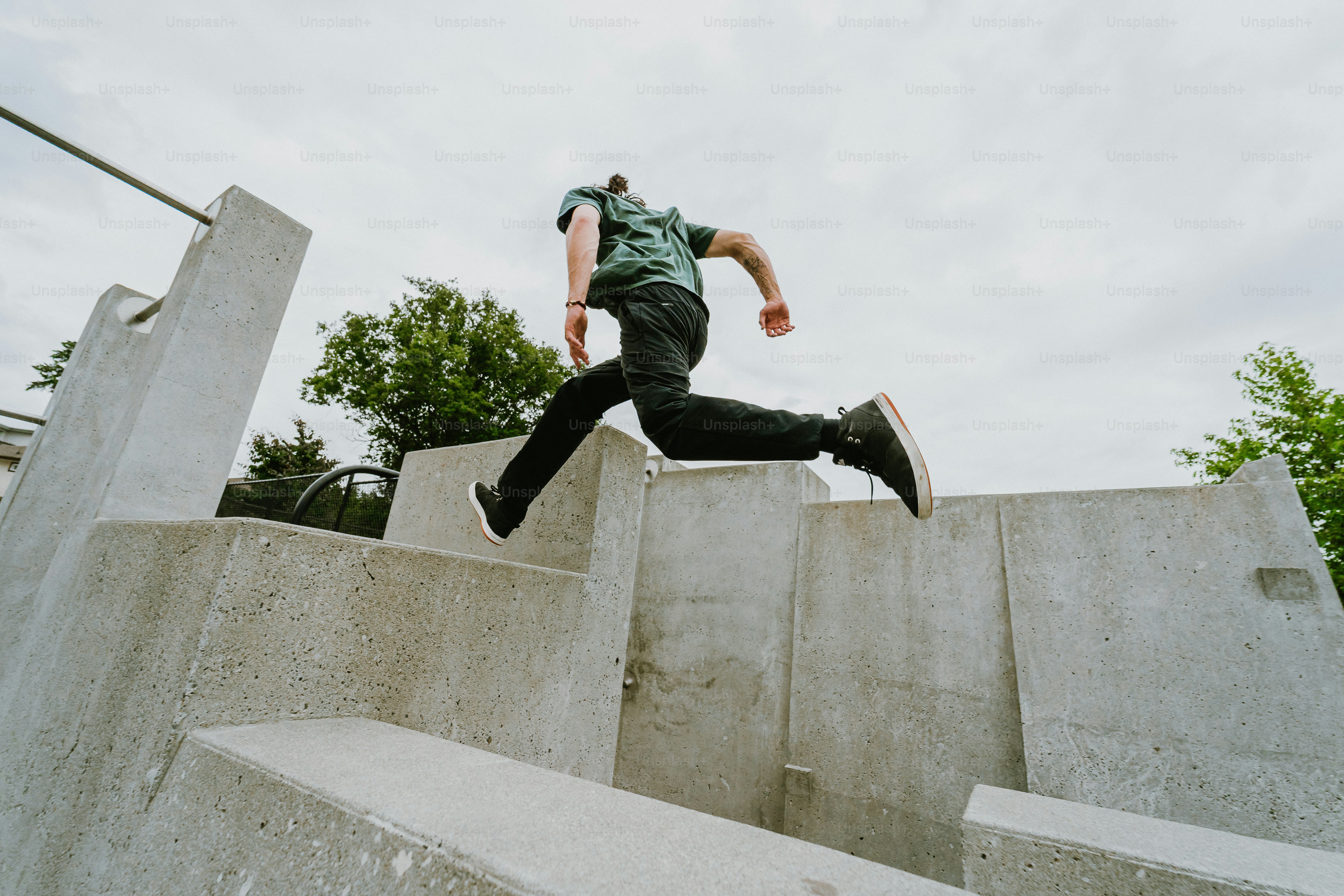 Man leaping over concrete obstacles in urban parkour