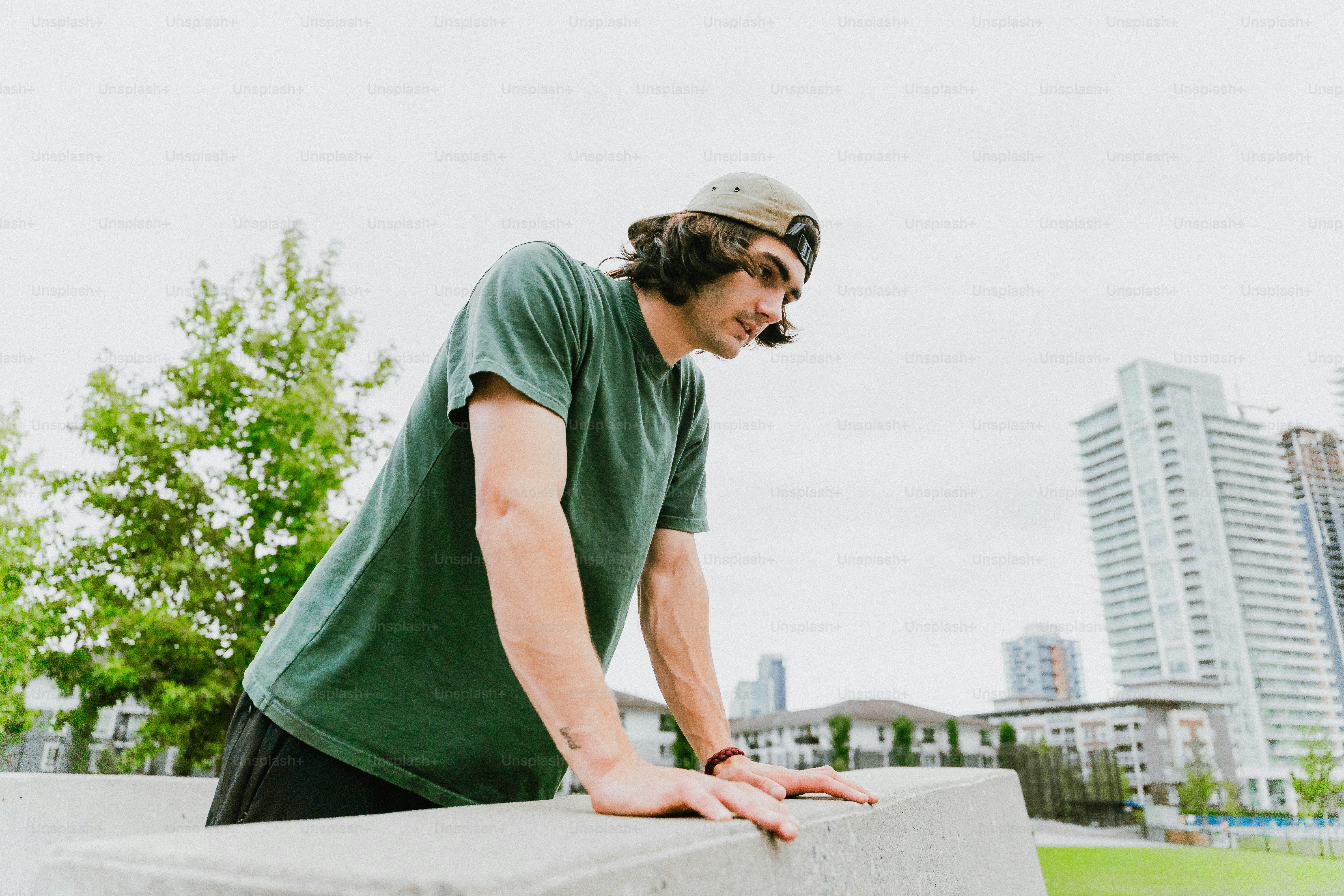 Man leaning on concrete wall in city park