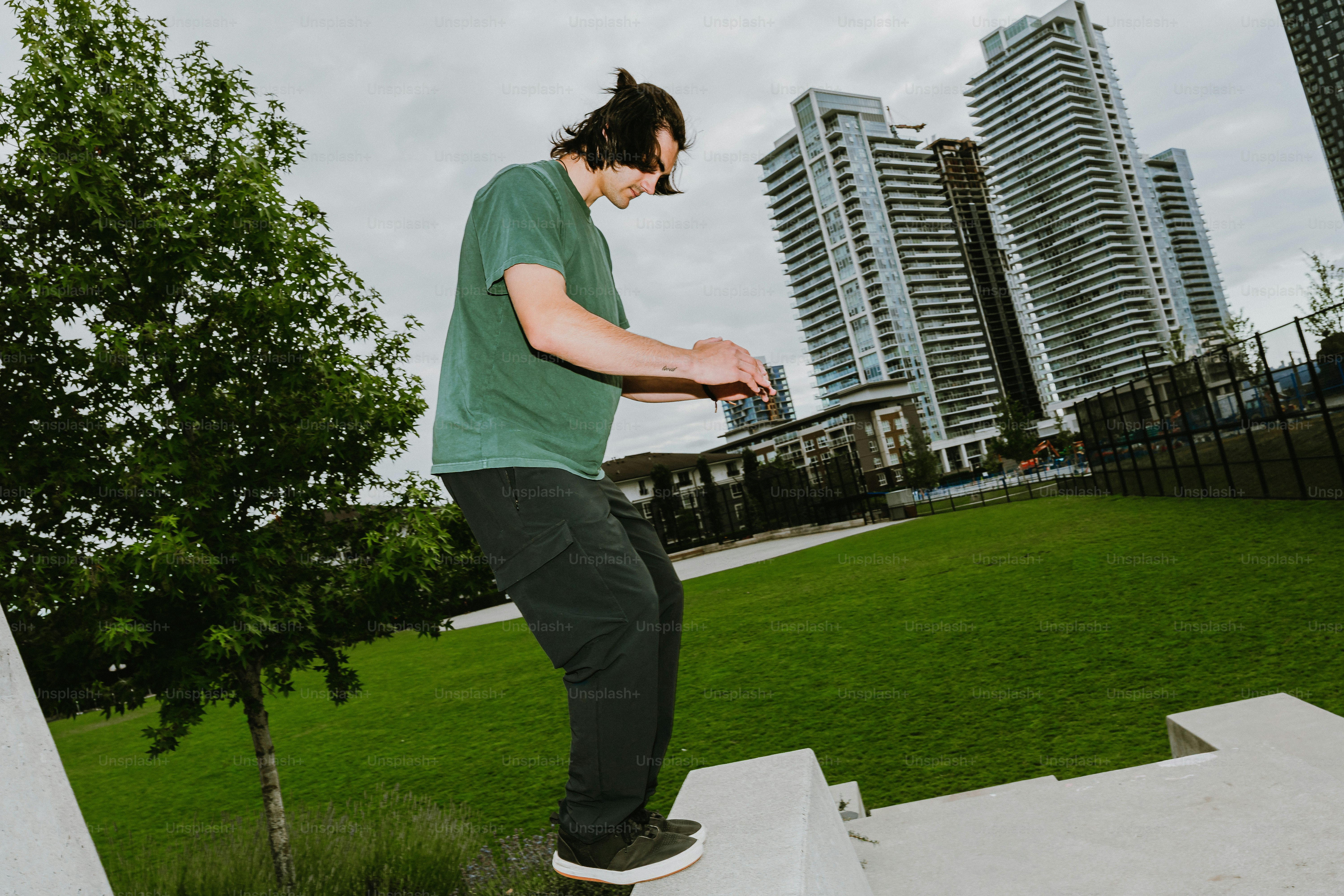 Man balancing on concrete ledge in urban park