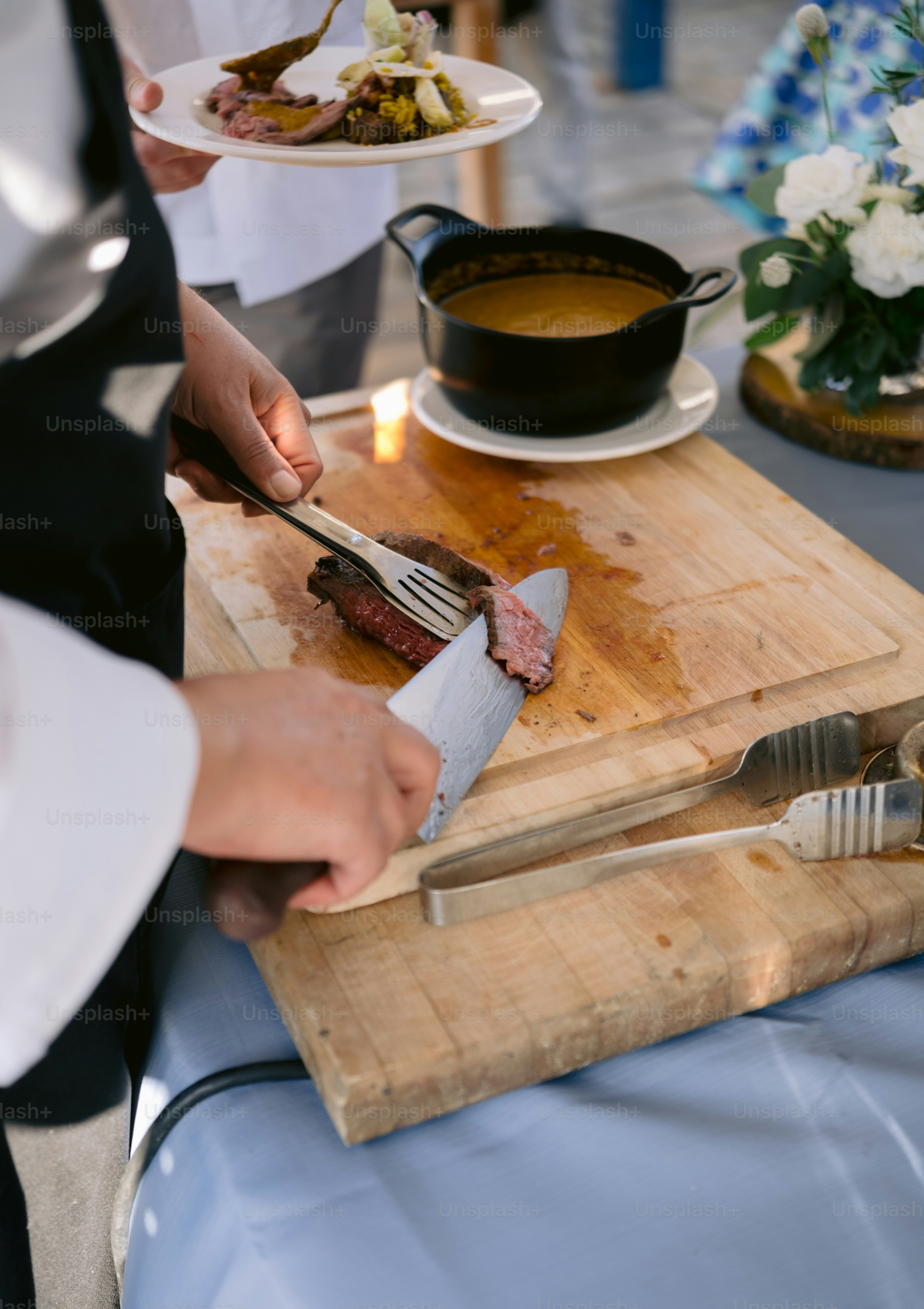 Pessoa fatiando carne cozida em tábua de madeira