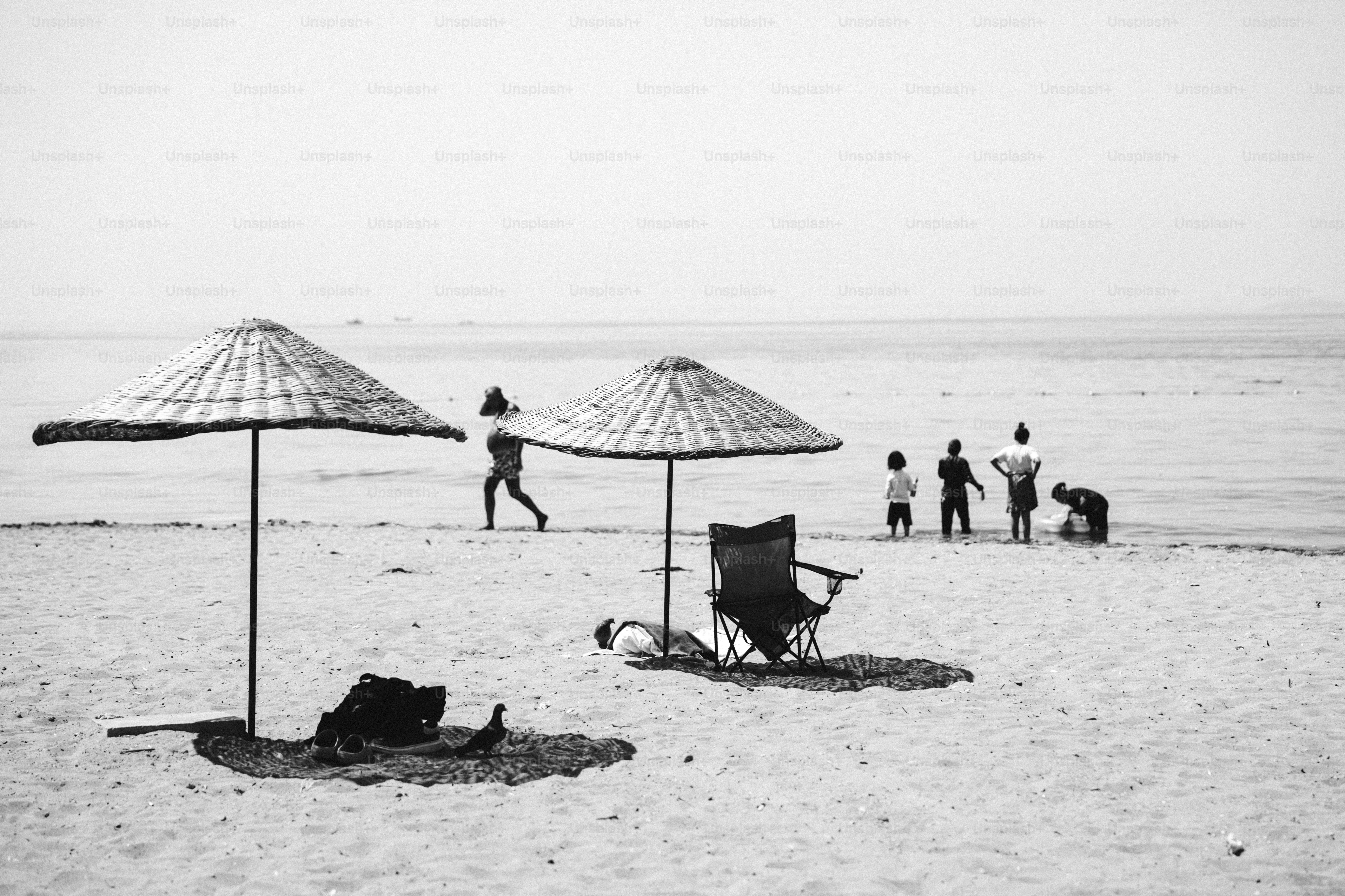 Black and white beach scene with umbrellas and people