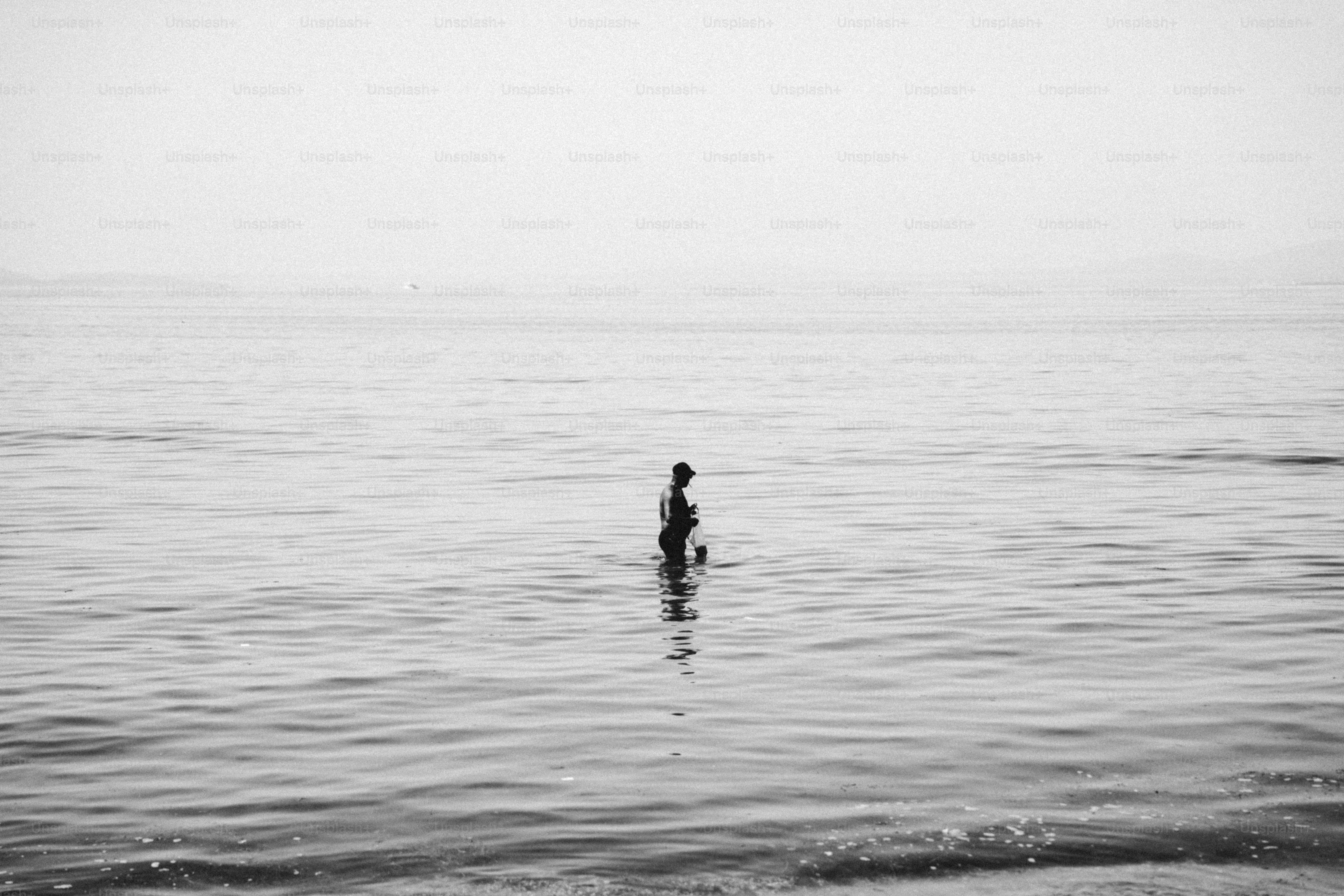 Solitary figure standing in calm ocean