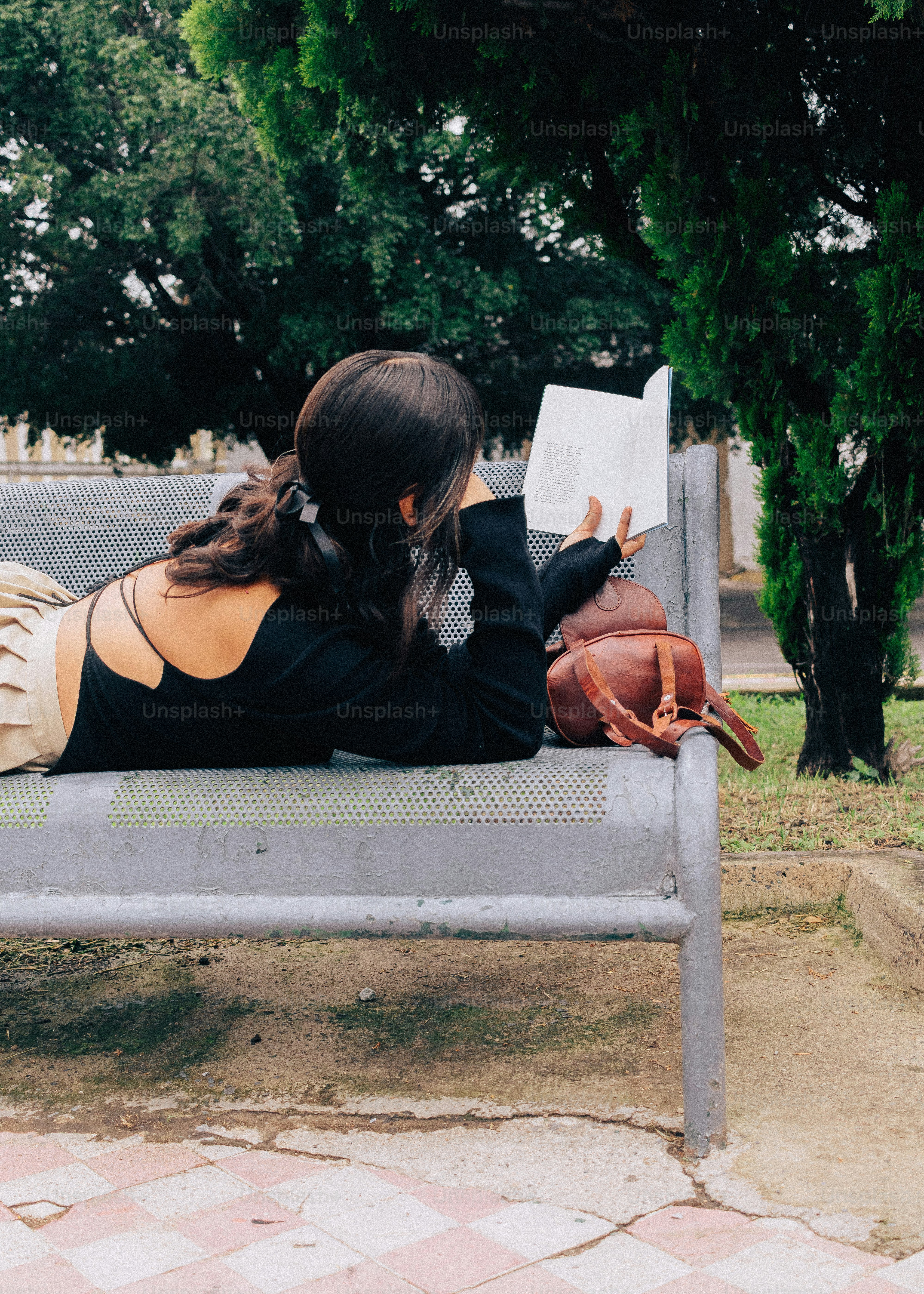 Person liest ein Buch auf der Parkbank