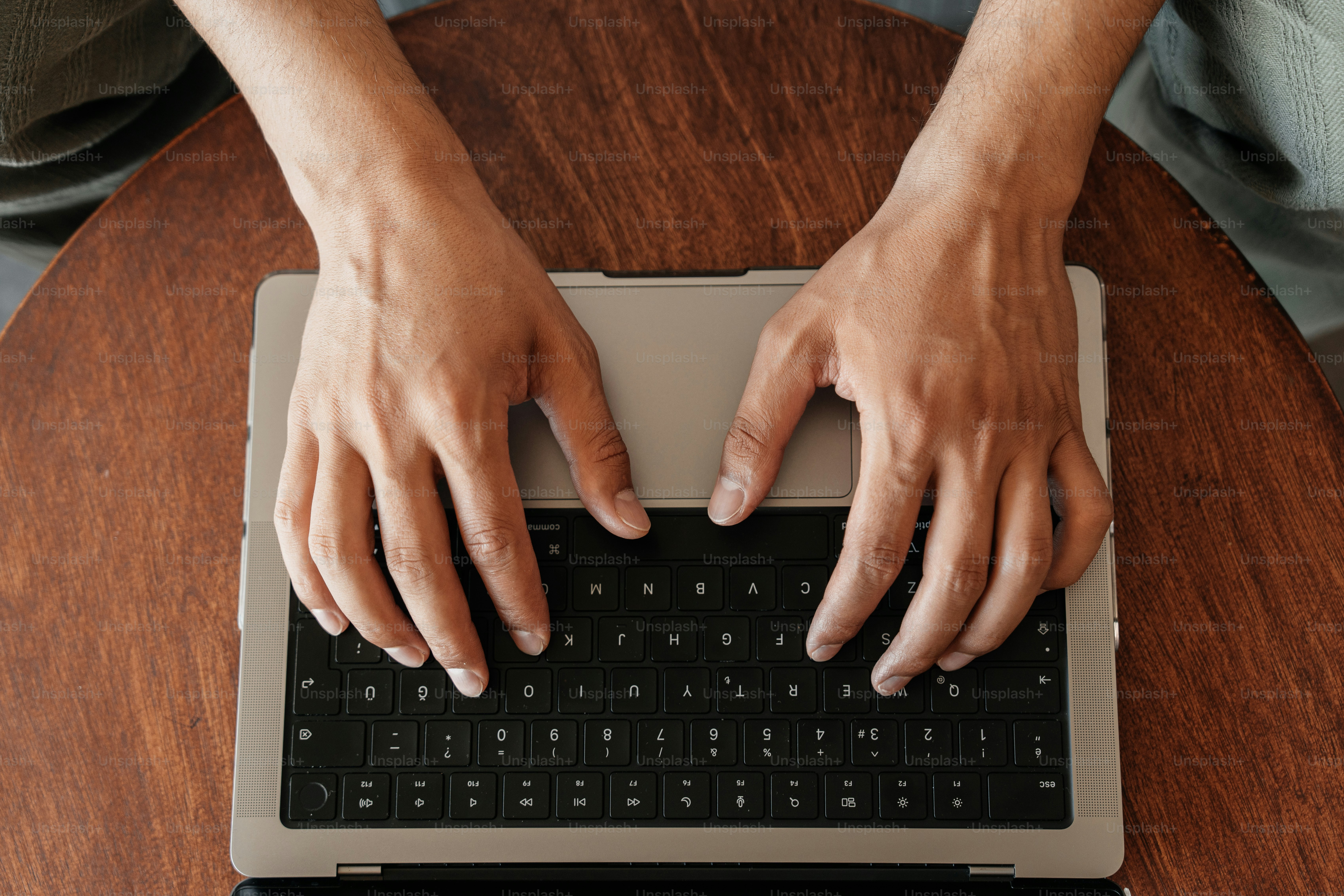 Hände tippen auf der Laptop-Tastatur - Foto auf Unsplash+