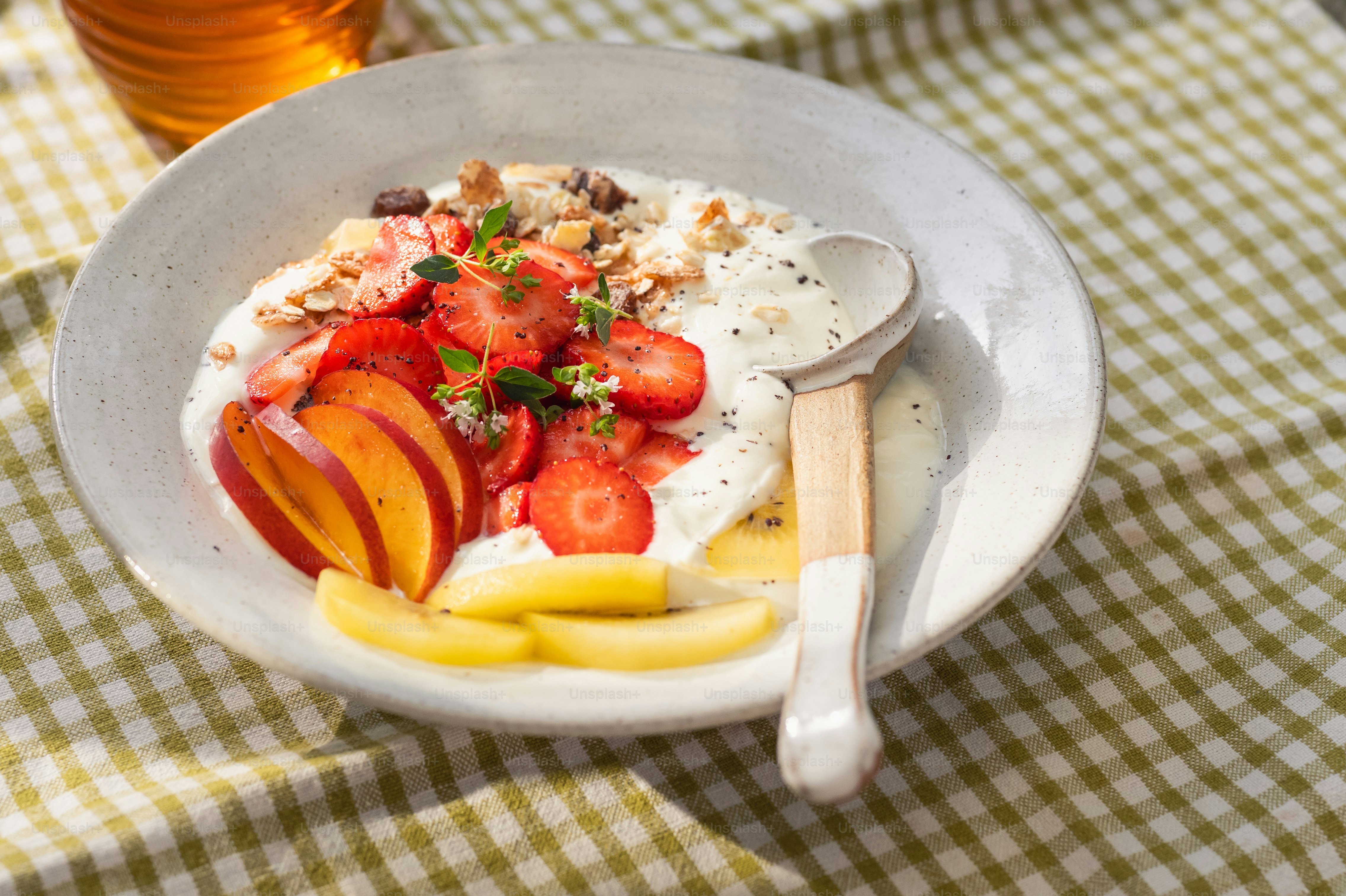 Fruit and granola yogurt bowl on checkered tablecloth