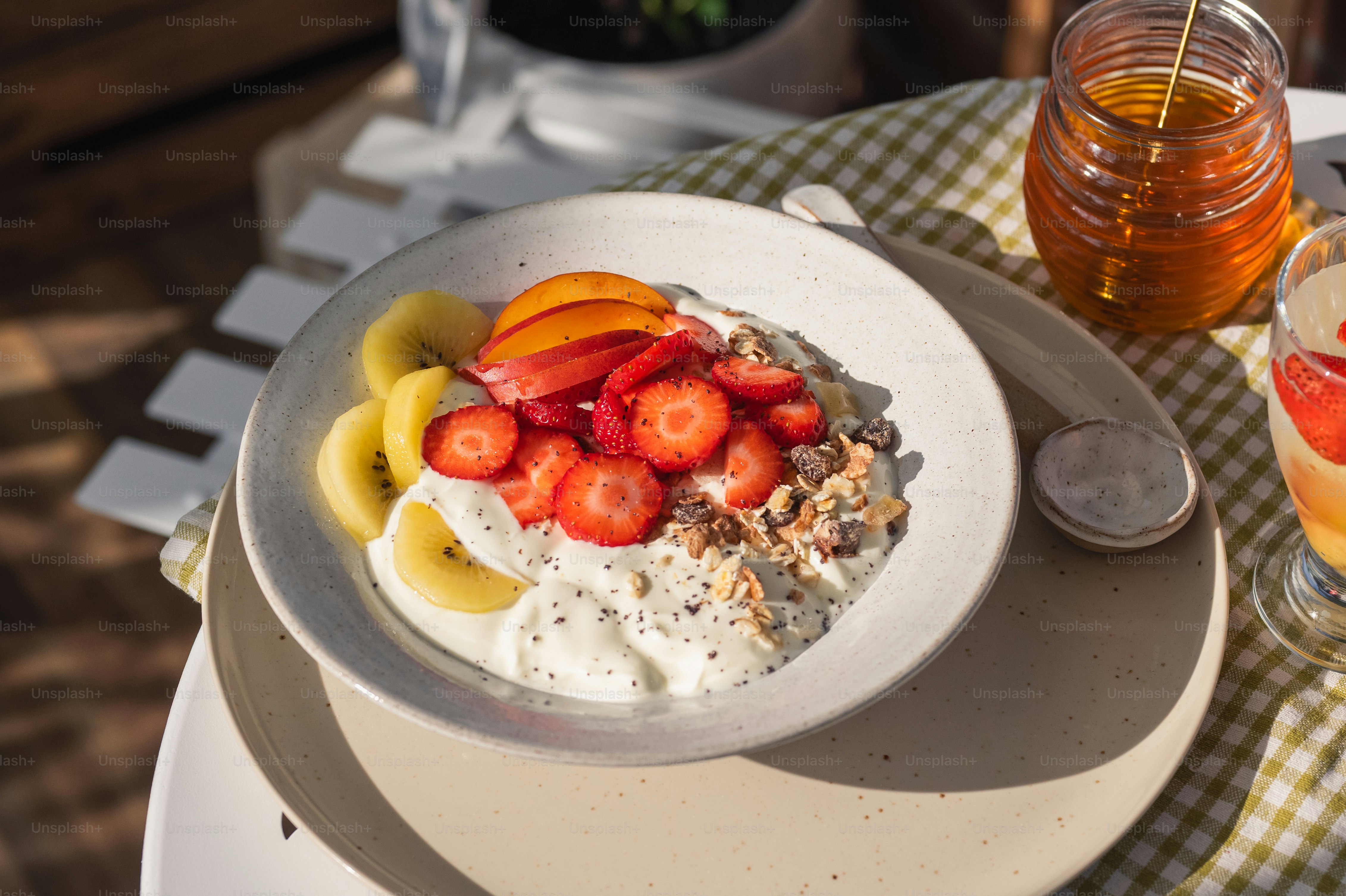 Breakfast yogurt bowl with fruit, granola, and honey.