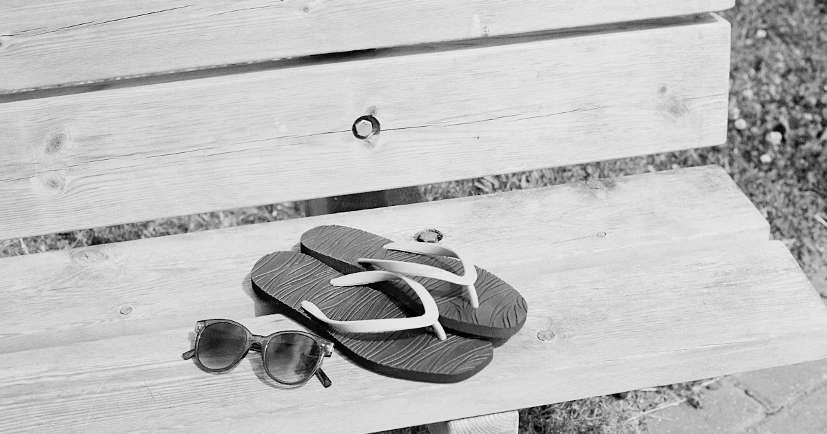Flip-flops and sunglasses resting on a wooden bench photo – Summer ...