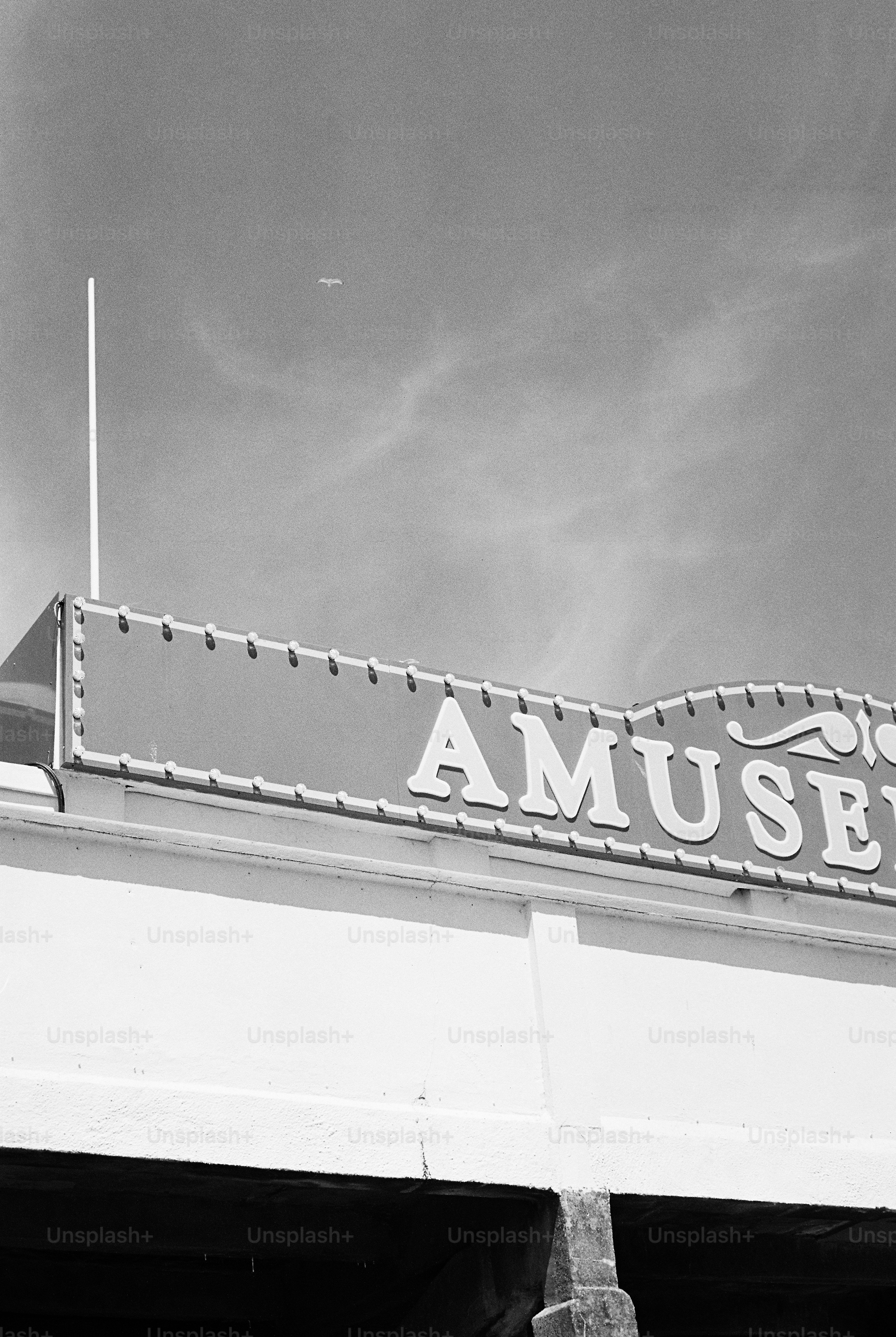 Amusement sign against cloudy sky