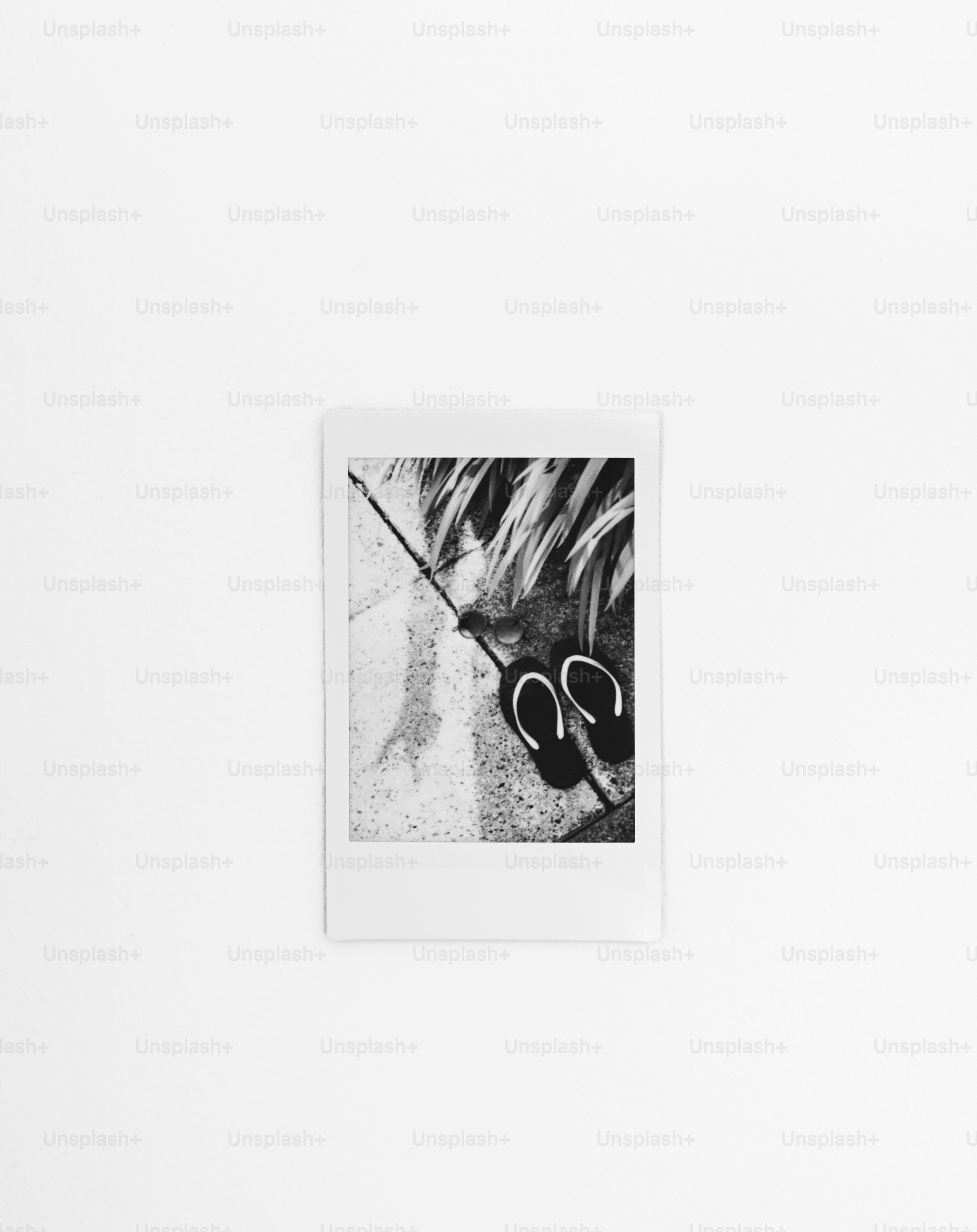 Black and white fuji instax print of flip-flops