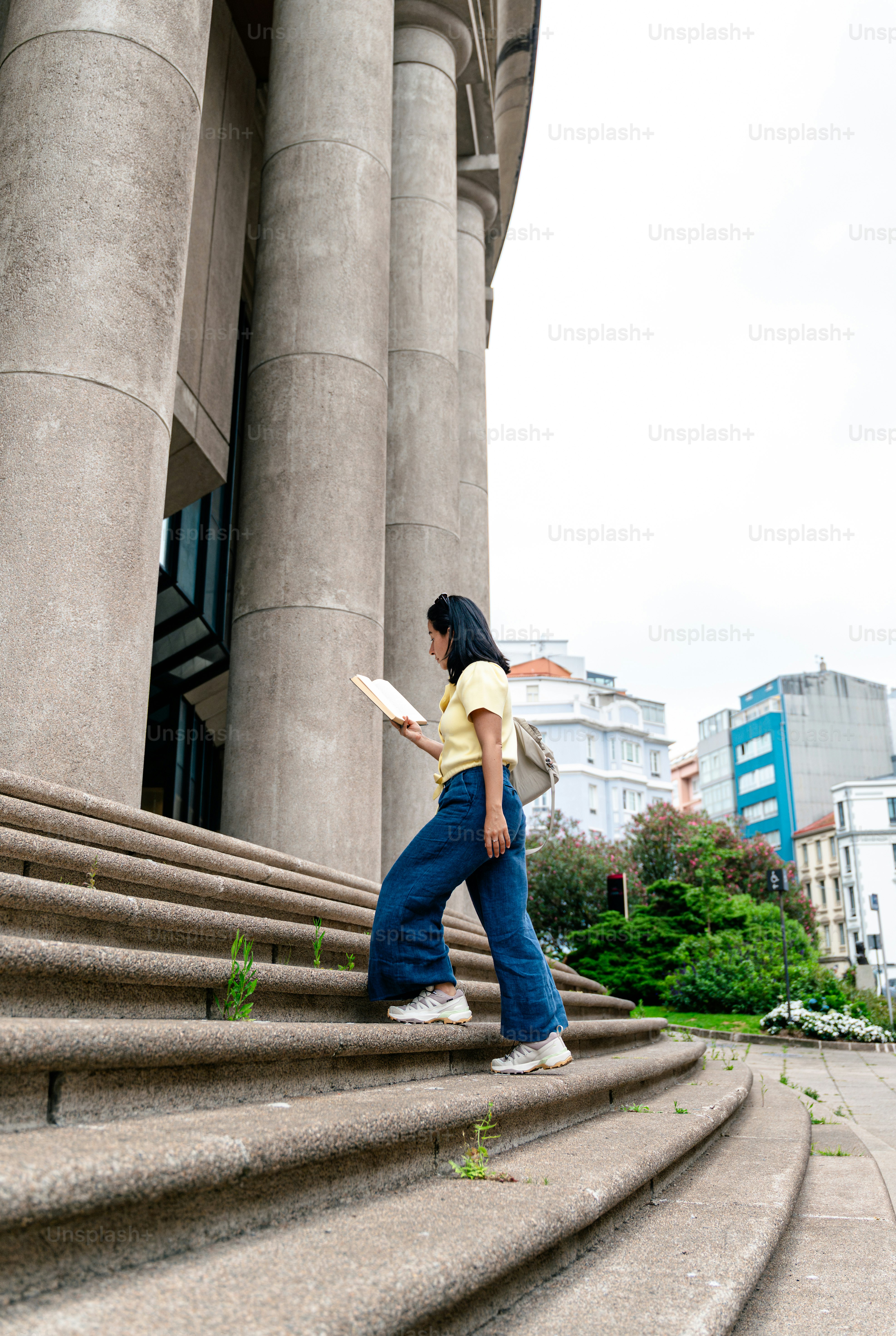 Woman ascending stone steps with book