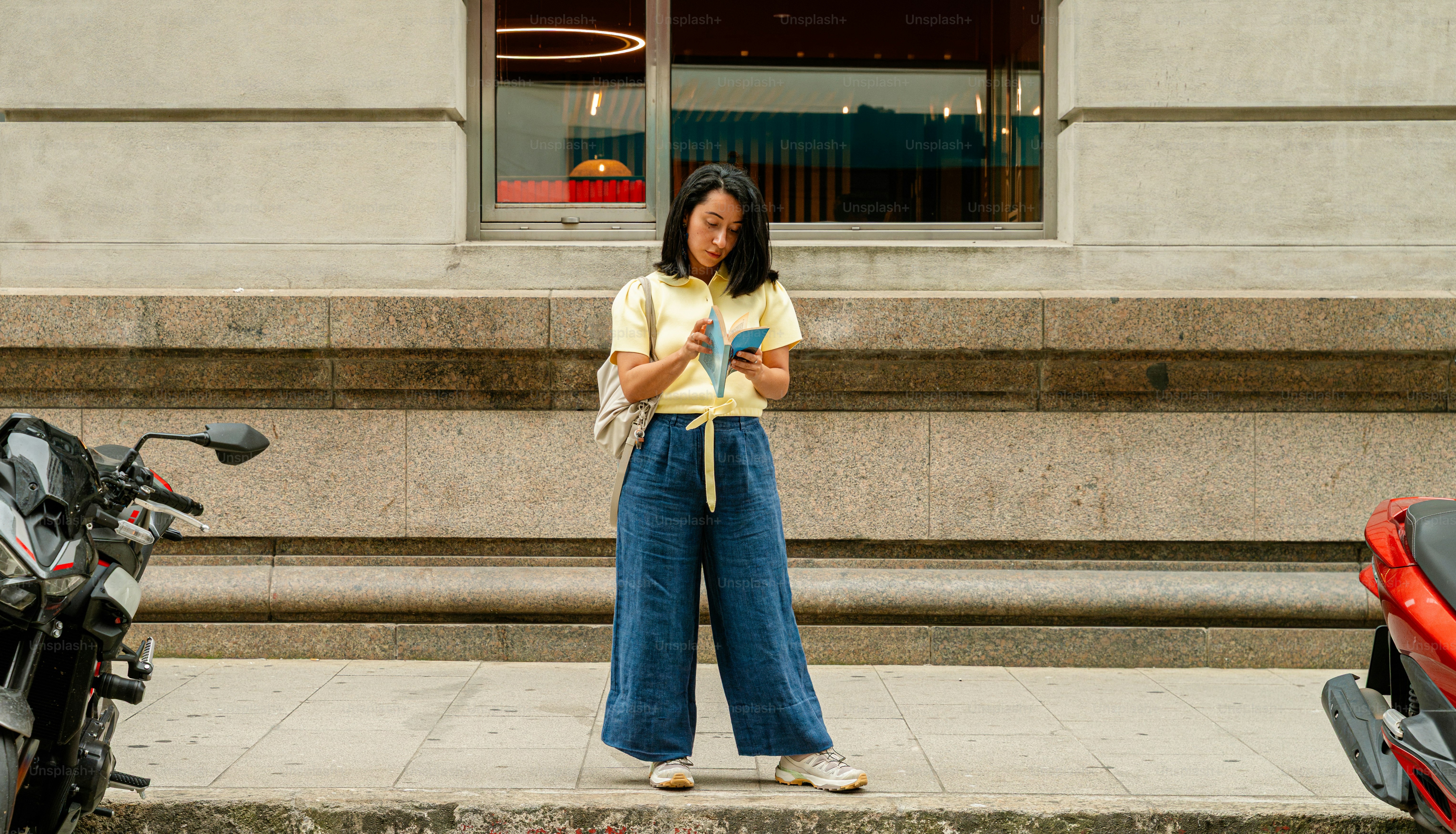 Woman standing on city street looking at smartphone