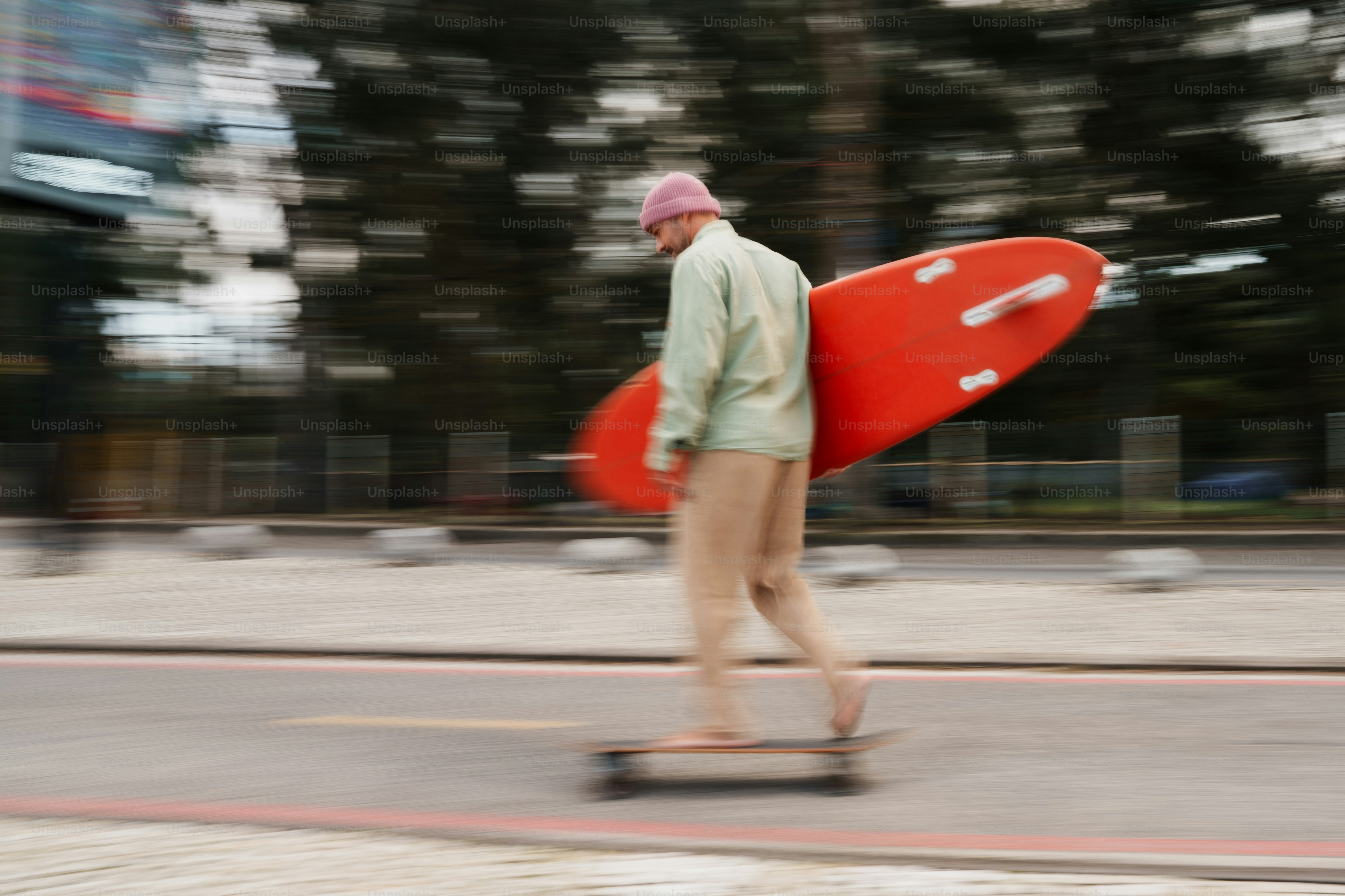 Skater carrying red surfboard on a street