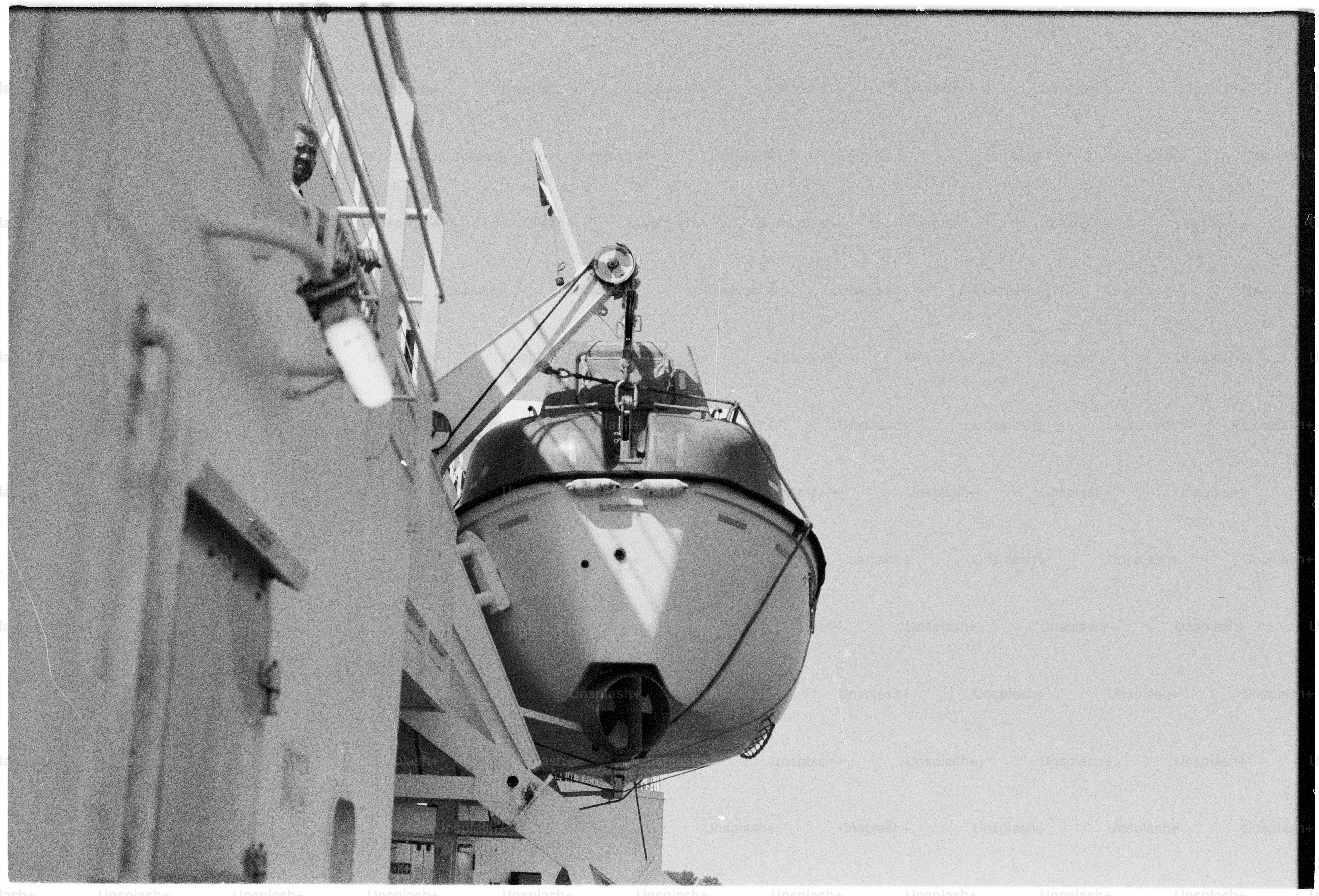 Black and white lifeboat on side of ship