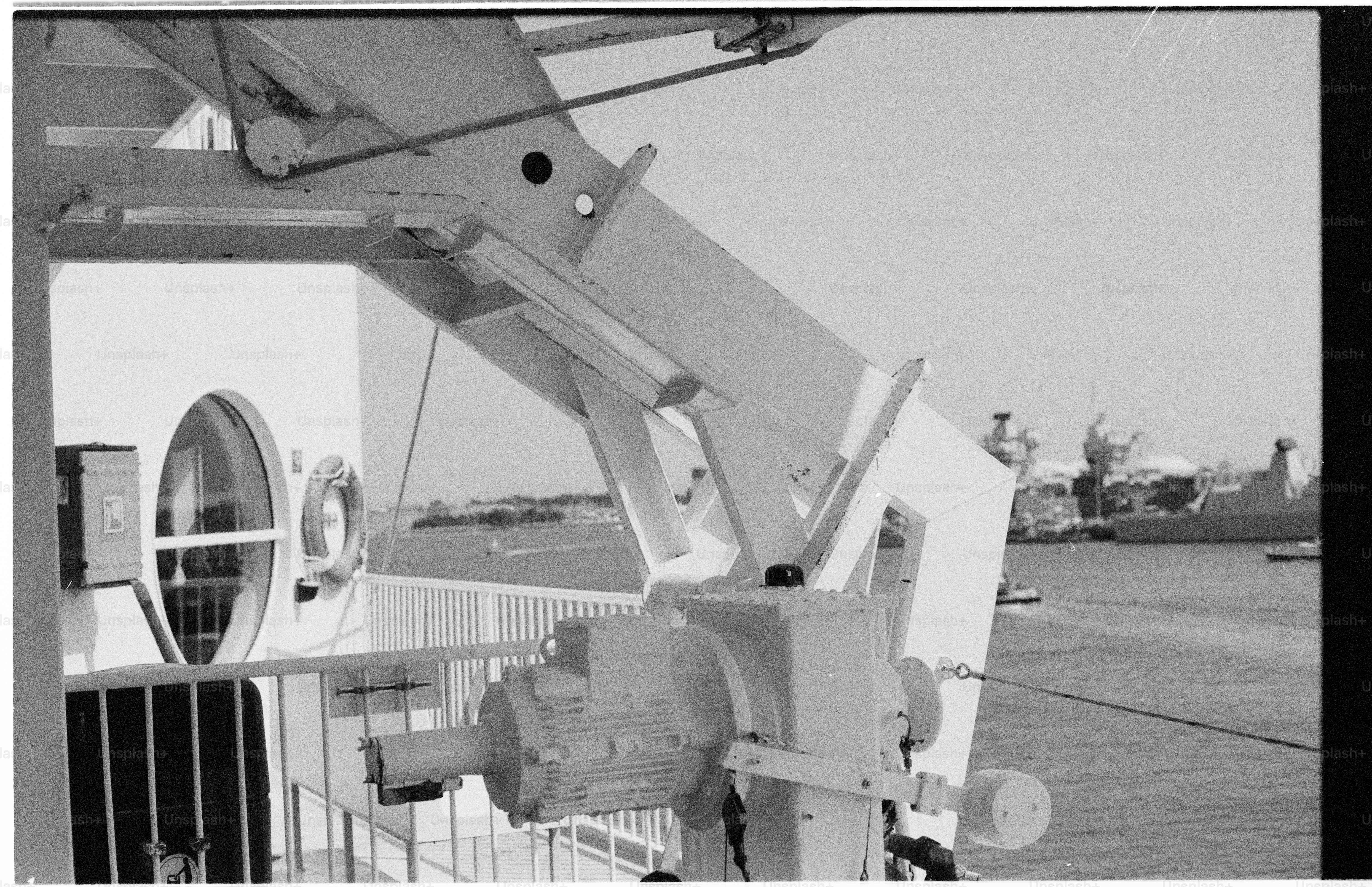 Ship's davit and railing with distant shoreline