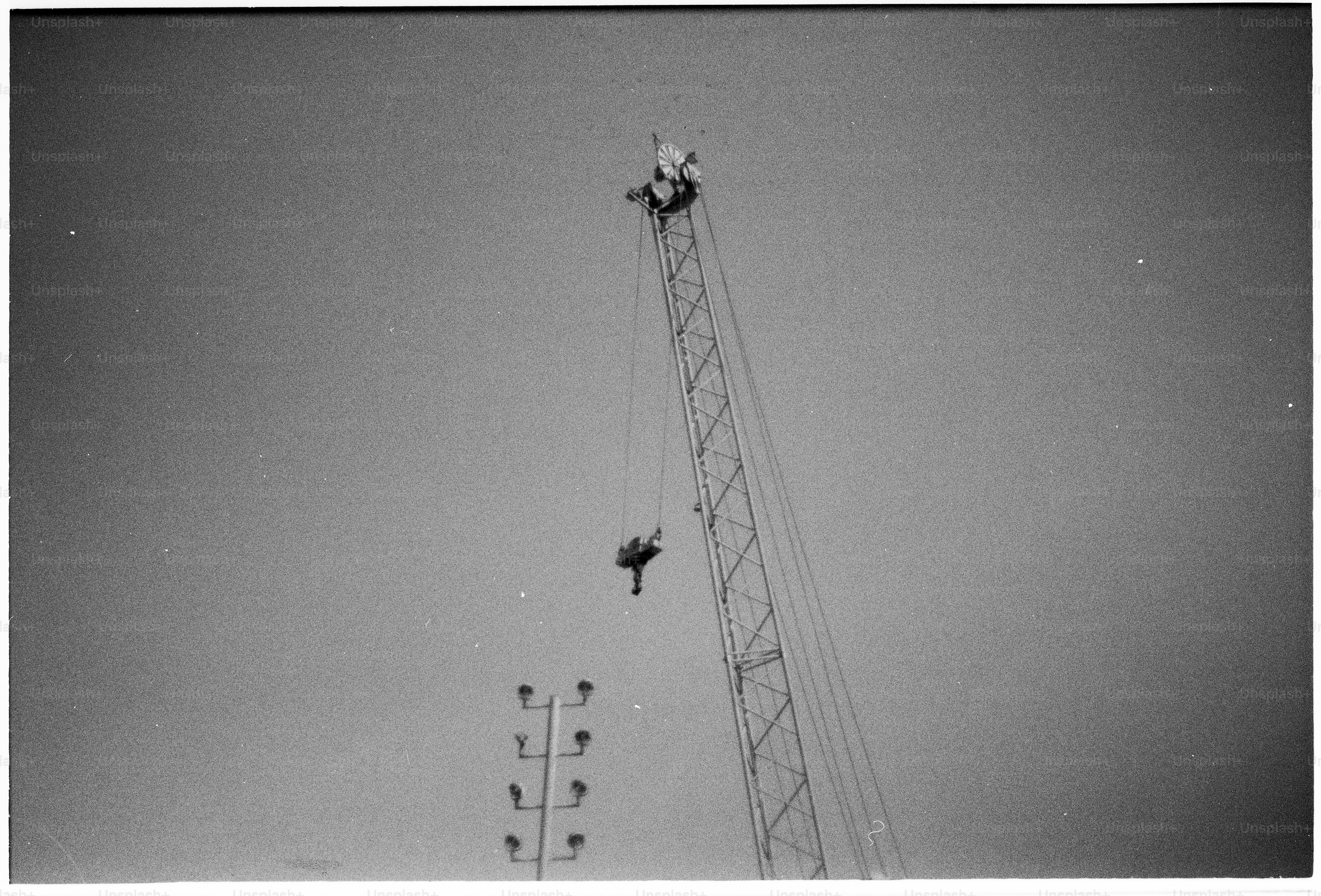 Worker atop a large crane against clear sky